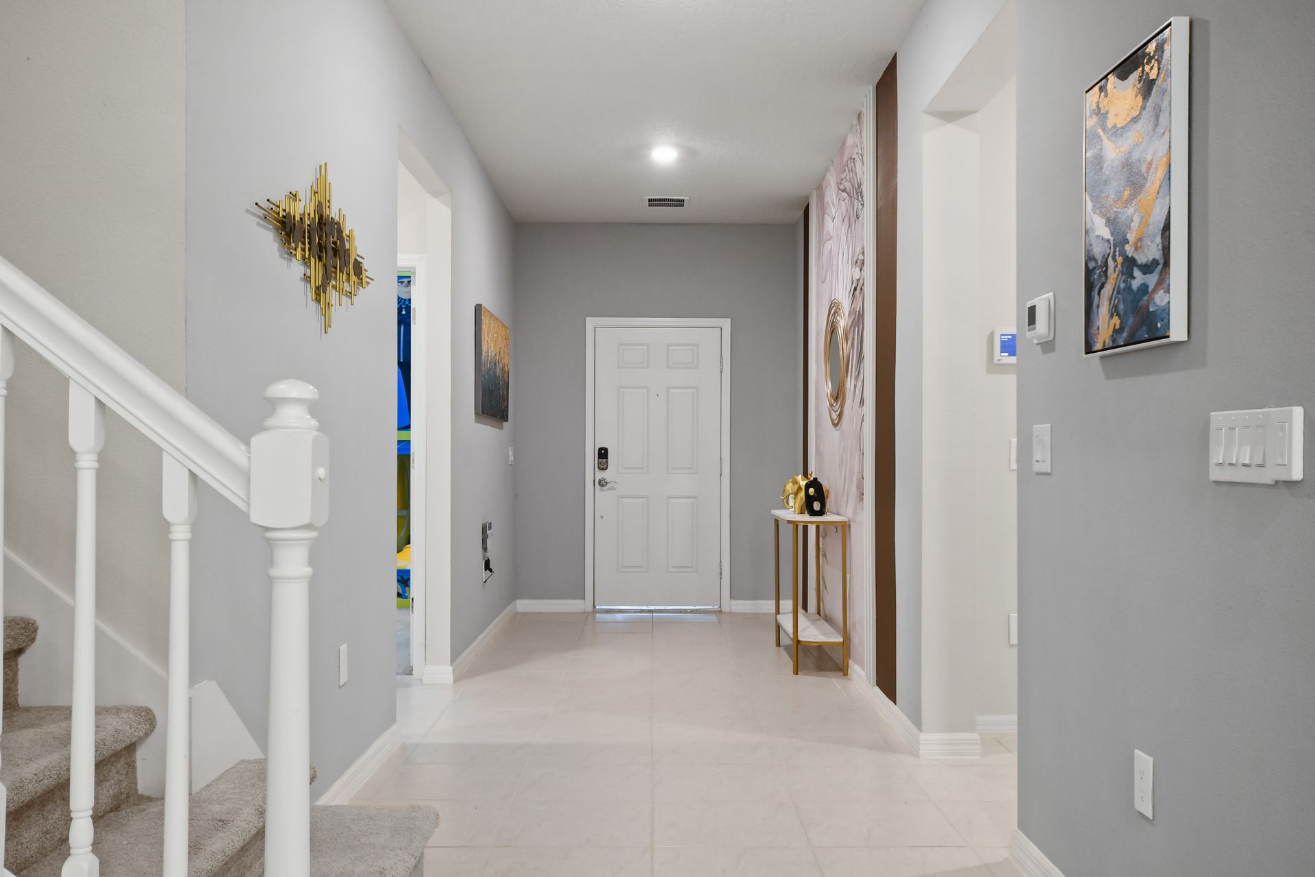 Bright and stylish entryway with modern art and sleek gold accents.

