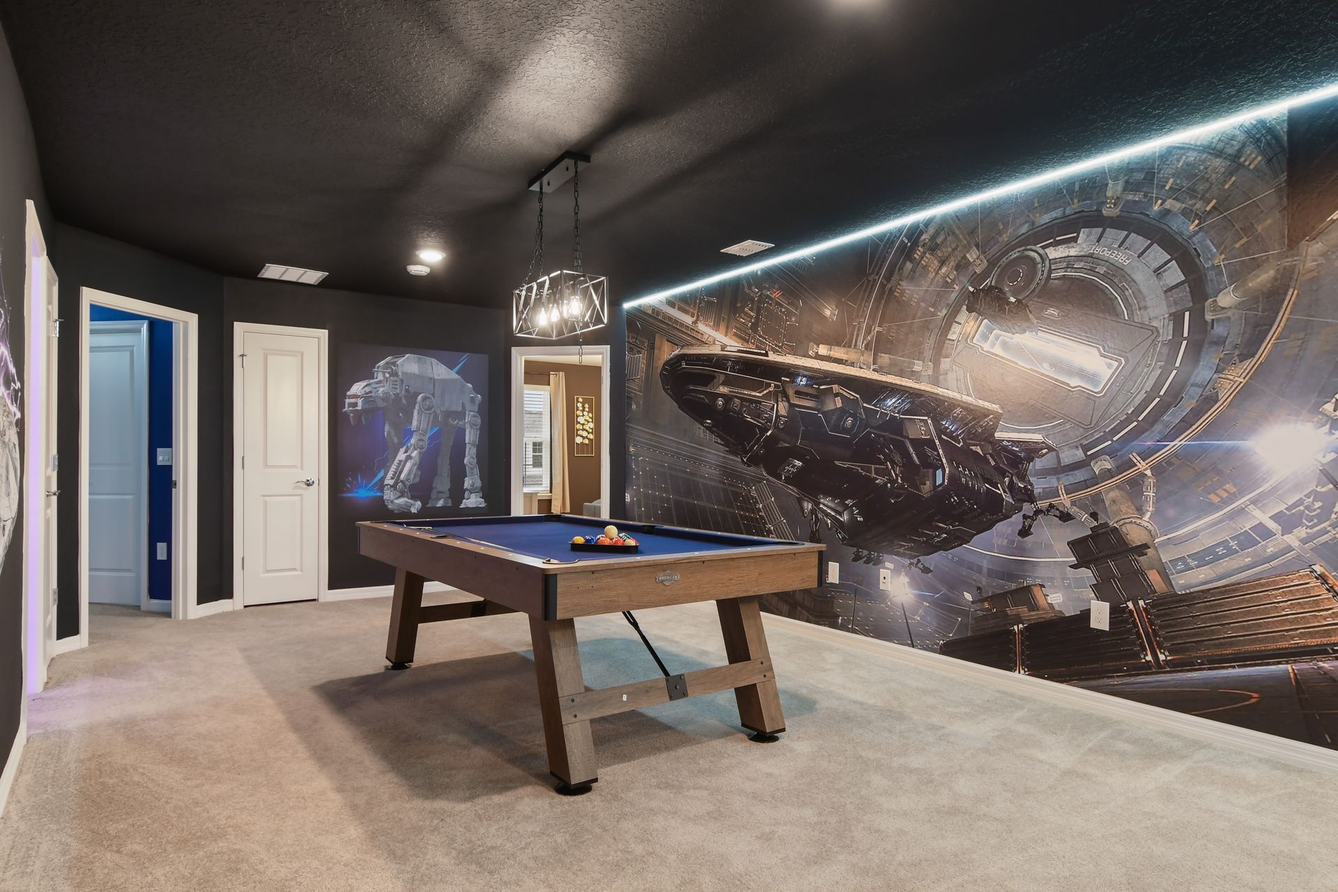 Futuristic game room with pool table and starship wall murals for epic battles.