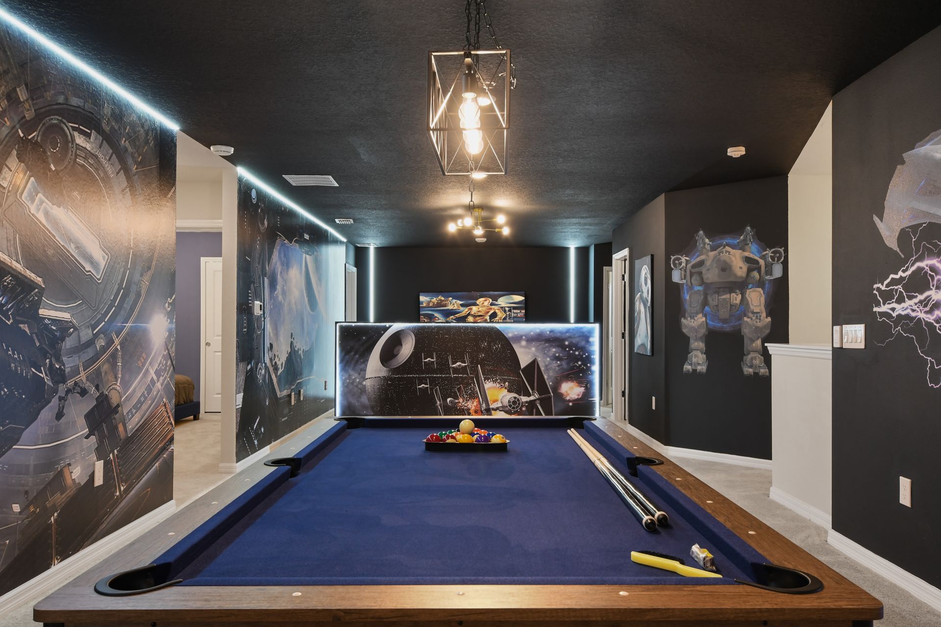 Cinematic Star Wars game loft with a full-size pool table and glowing wall art.