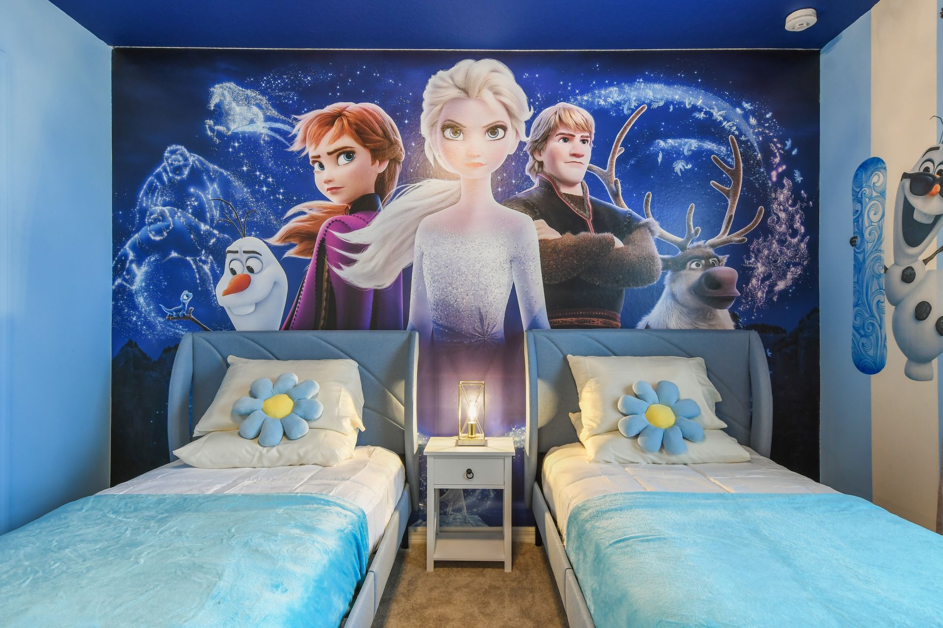 Enchanting Frozen twin room with bold character mural and cozy snowflake vibes.