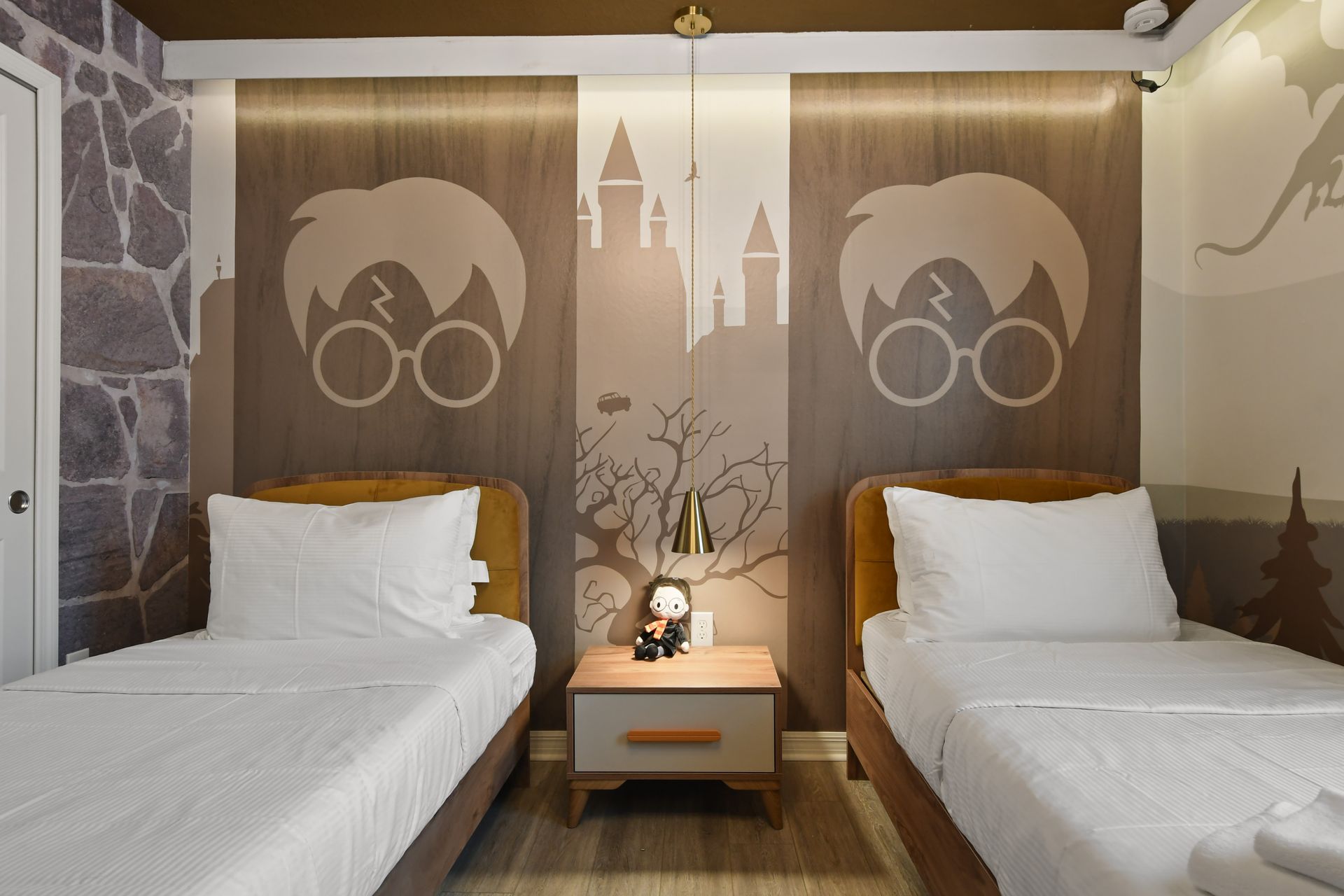 Wizard-themed twin room with magical mural, cozy beds, gold curtains, and TV
