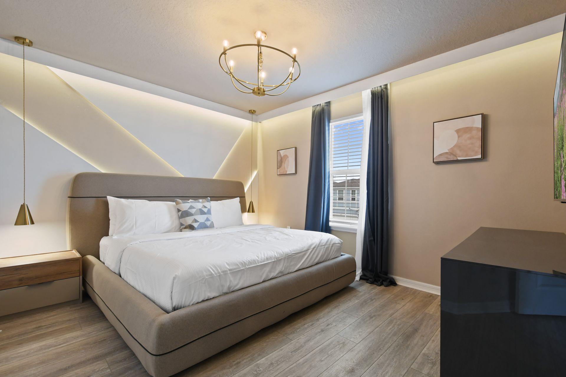 Modern bedroom with ambient lighting, plush bedding, and elegant gold accents.