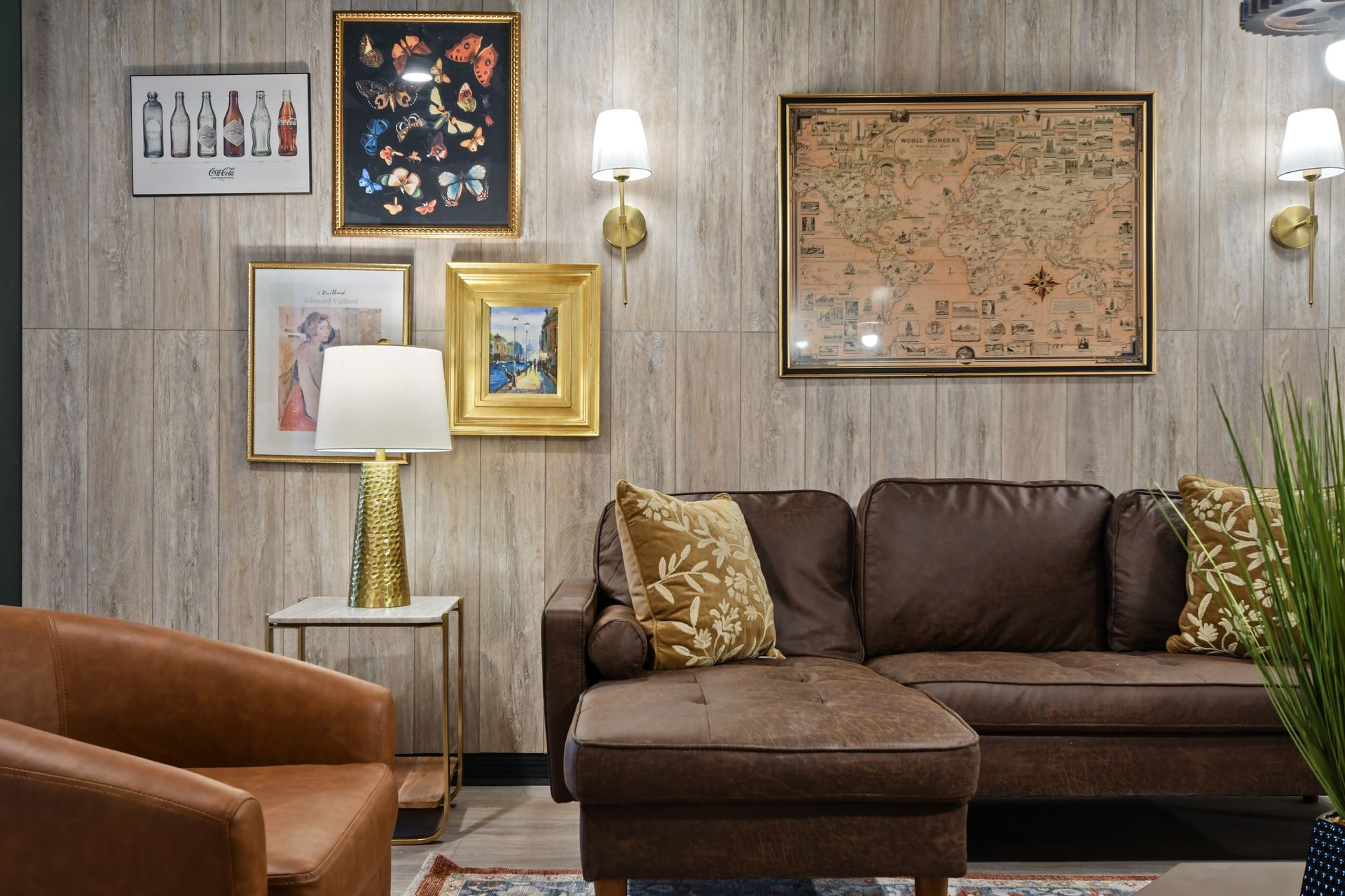 Cozy vintage lounge with leather sofa, map art, golden lamp, and warm decor
