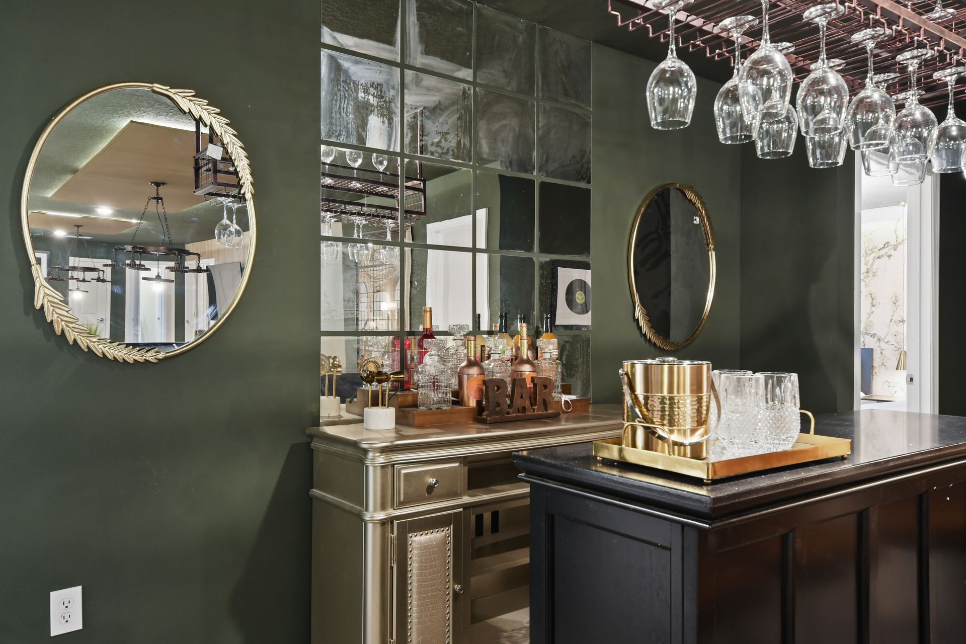 Chic home bar with mirrored backsplash, gold accents, and elegant glassware.