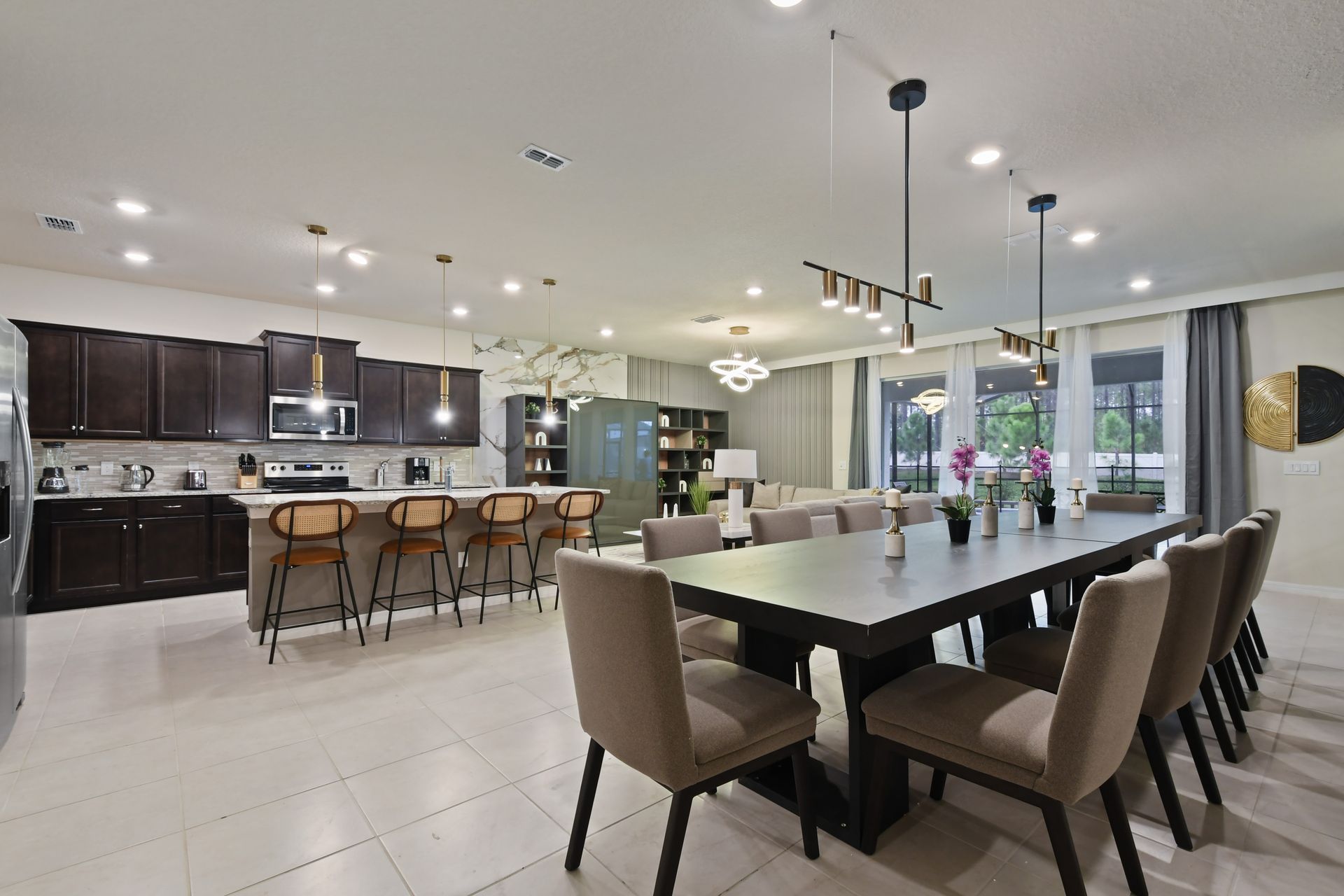 Spacious open-concept kitchen and dining area with modern lighting and seating.