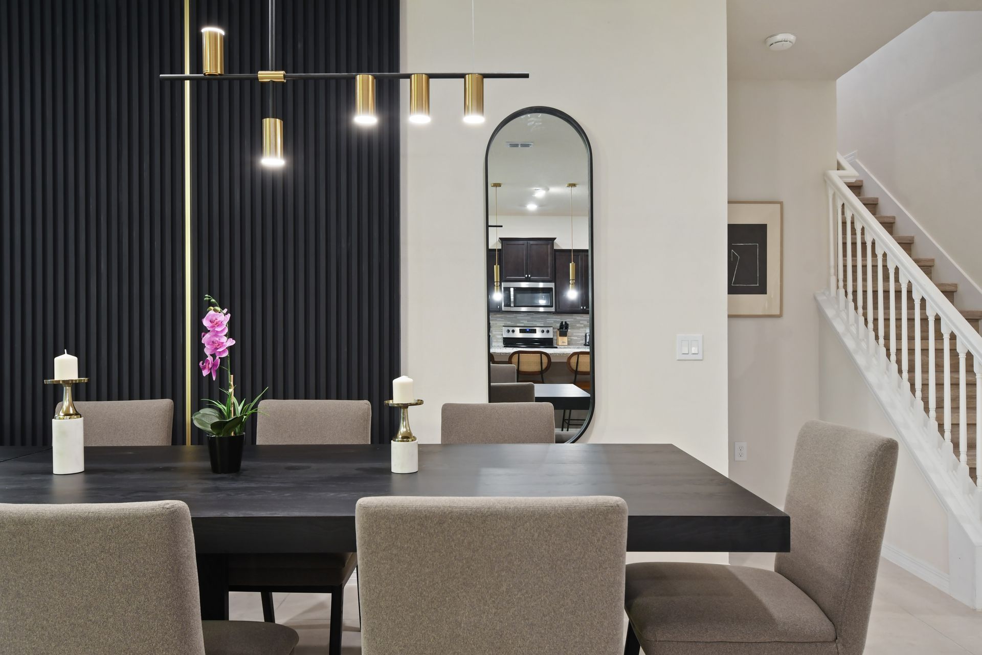Modern dining area with sleek decor, gold accents, and warm lighting for gatherings.