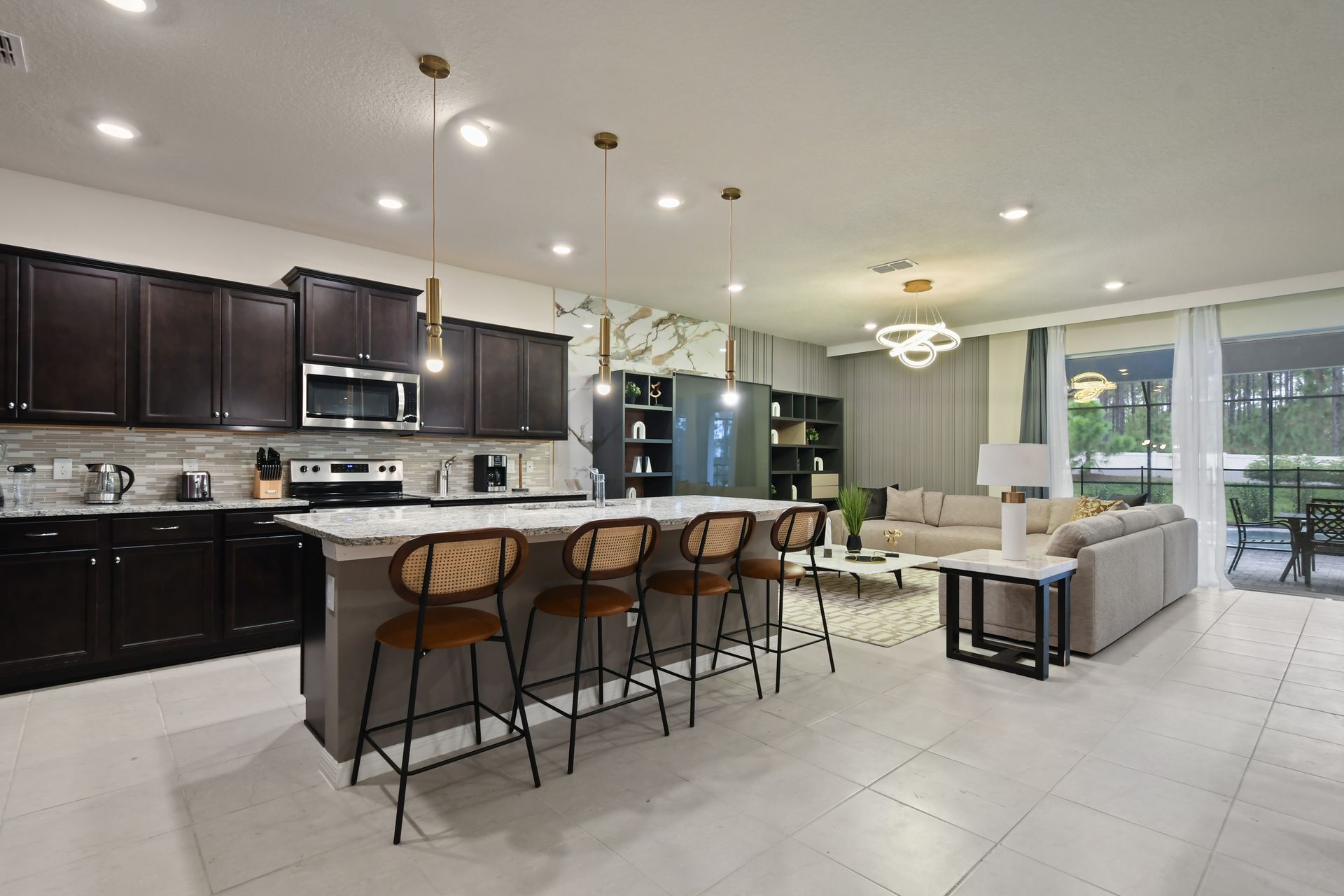 Open-concept kitchen and living area with modern lighting and ample seating.