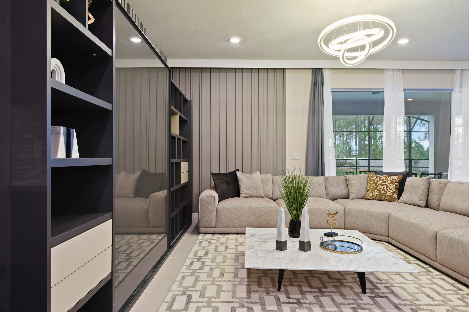 Spacious open-concept living area with modern lighting, marble accents, and cozy seating.