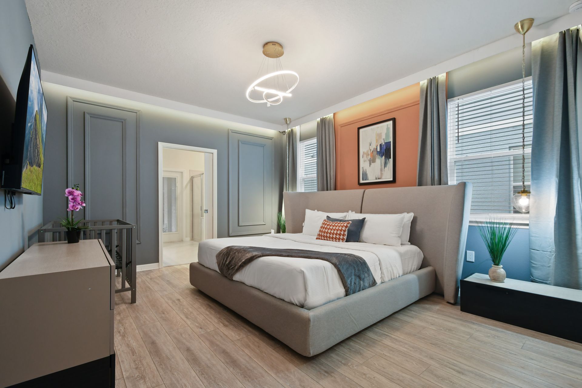 Modern chic bedroom with king bed, abstract art, stylish lighting, and calming colors
