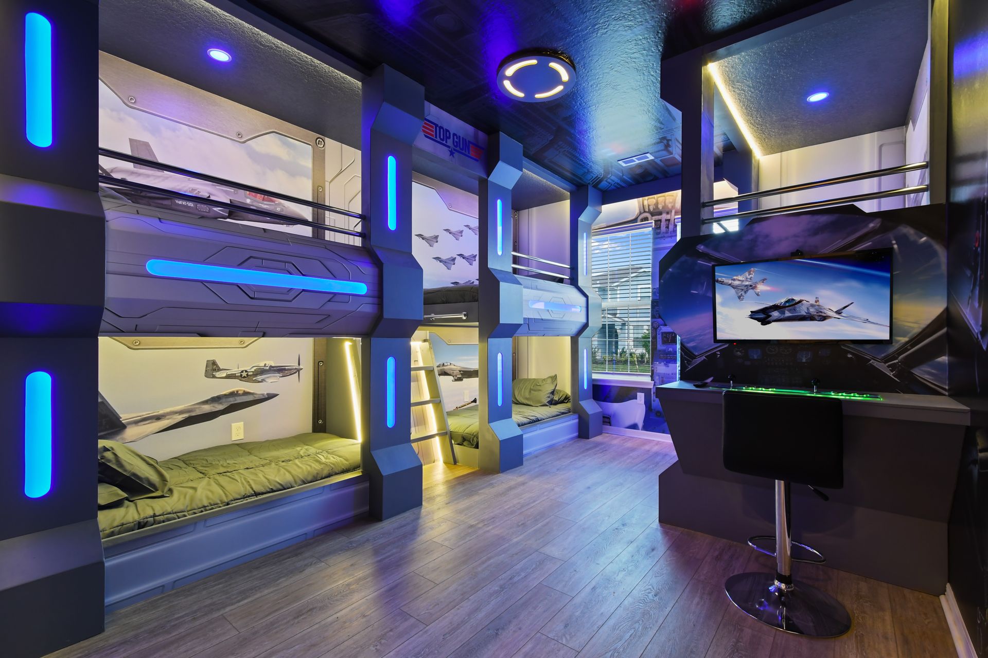 Aviation-themed bunk room with futuristic lighting and gaming setup for thrill-seekers.