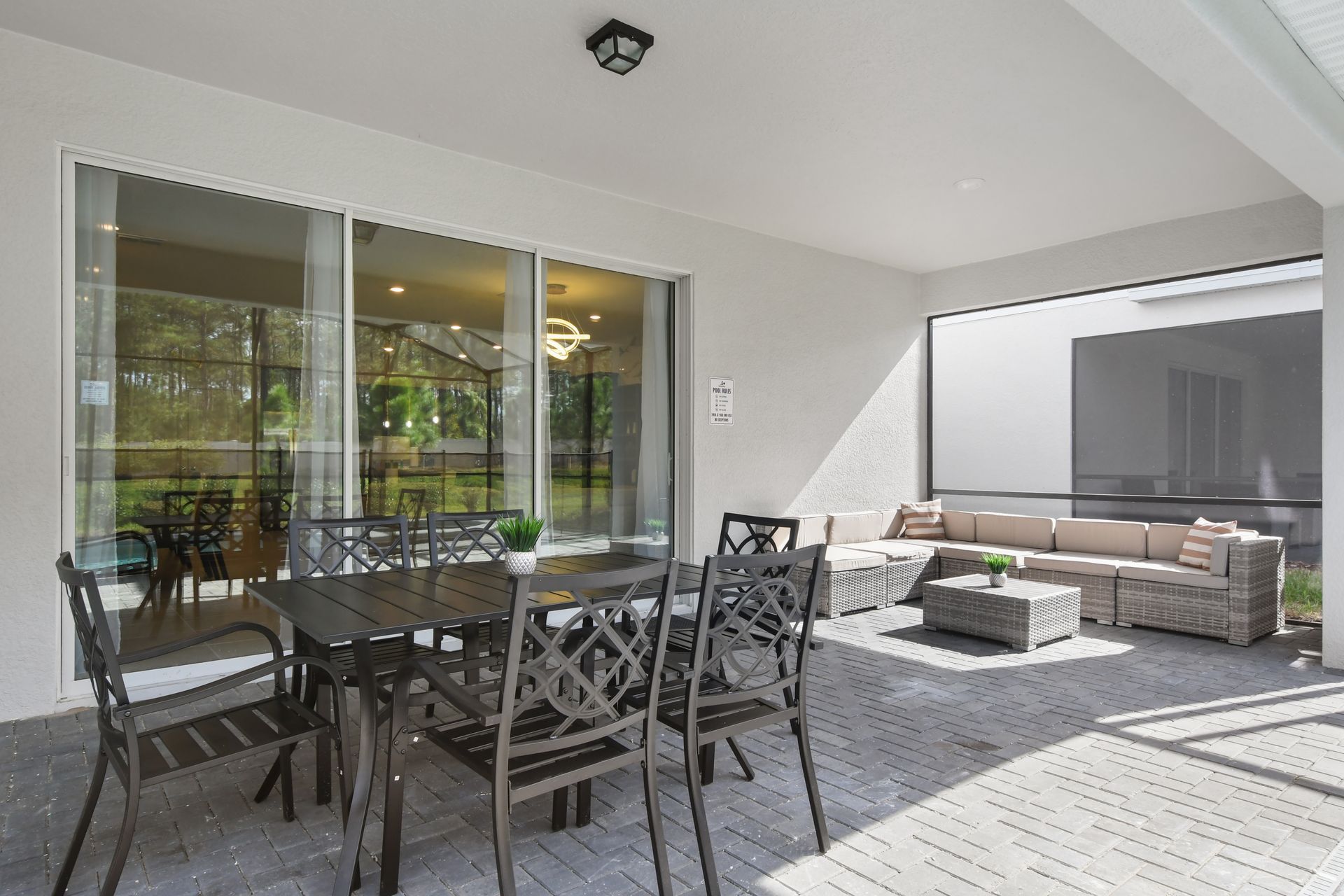 Spacious screened patio with dining set, comfy sectional sofa, and poolside relaxation
