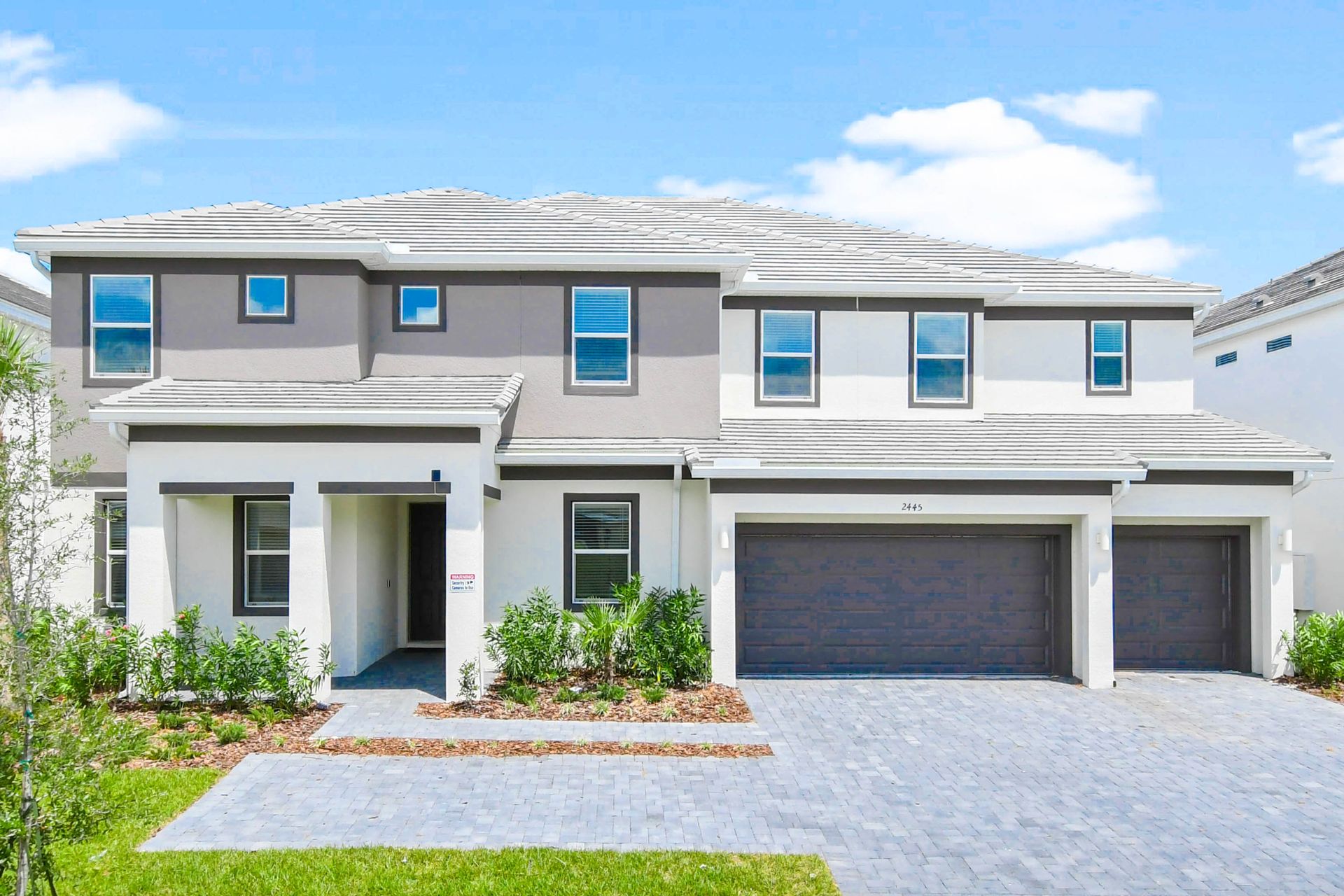 Modern two-story home with spacious driveway and landscaped front yard.