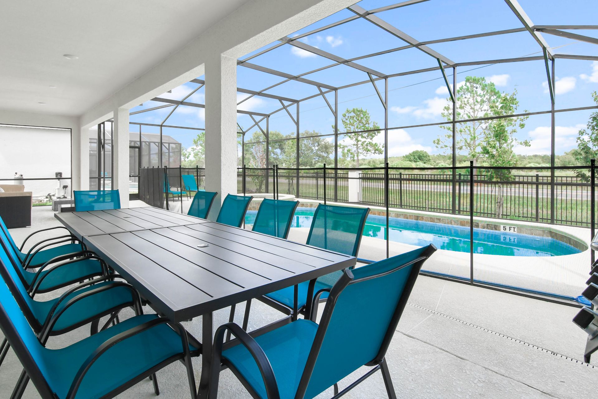 Spacious outdoor dining area with pool view, perfect for meals and gatherings.