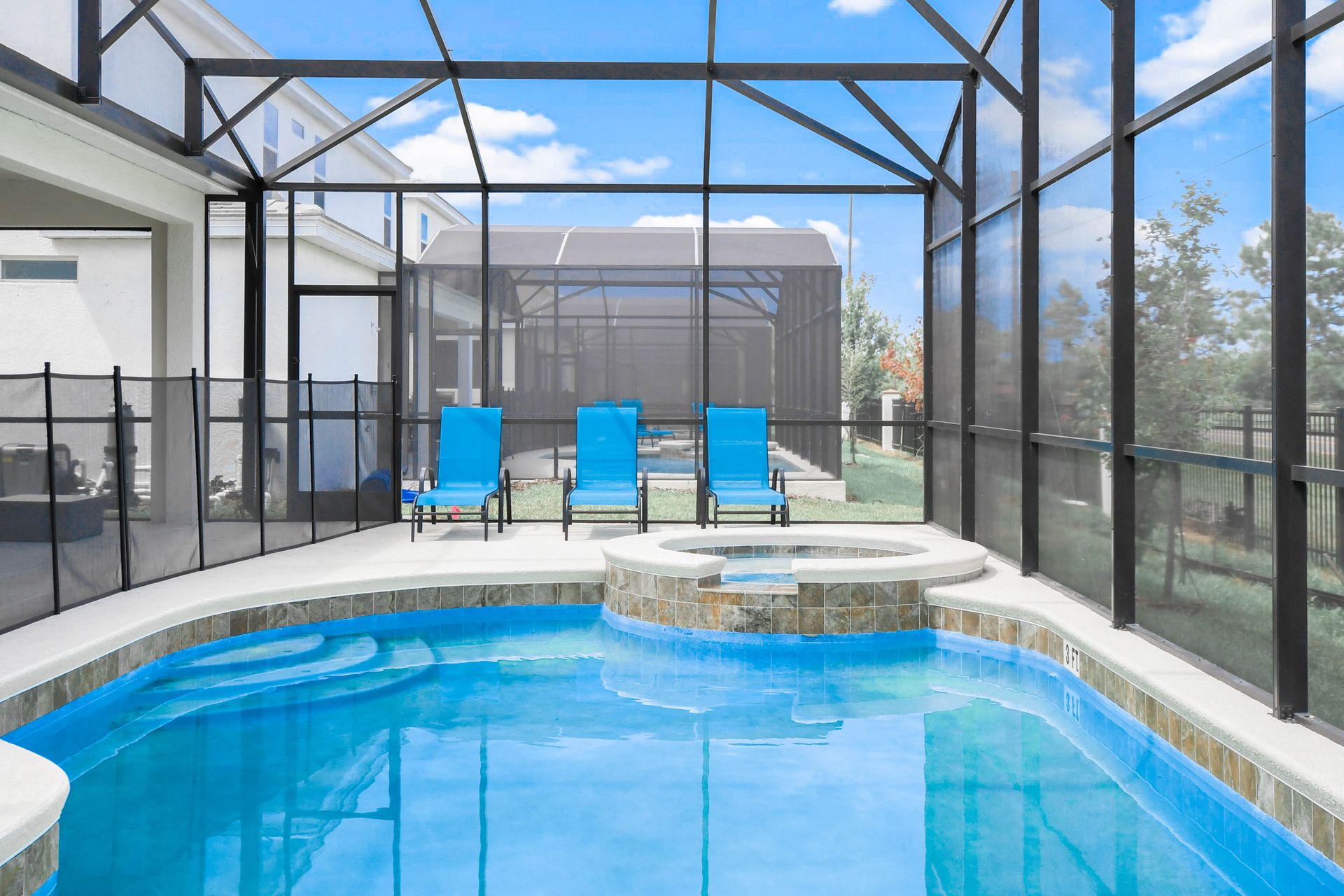 Private screened pool and spa area with lounge chairs, perfect for relaxation.