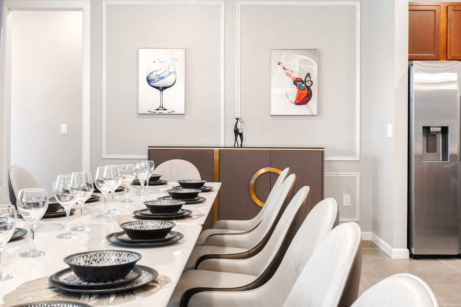 Elegant dining area with modern art, sleek table setting, and plush seating.