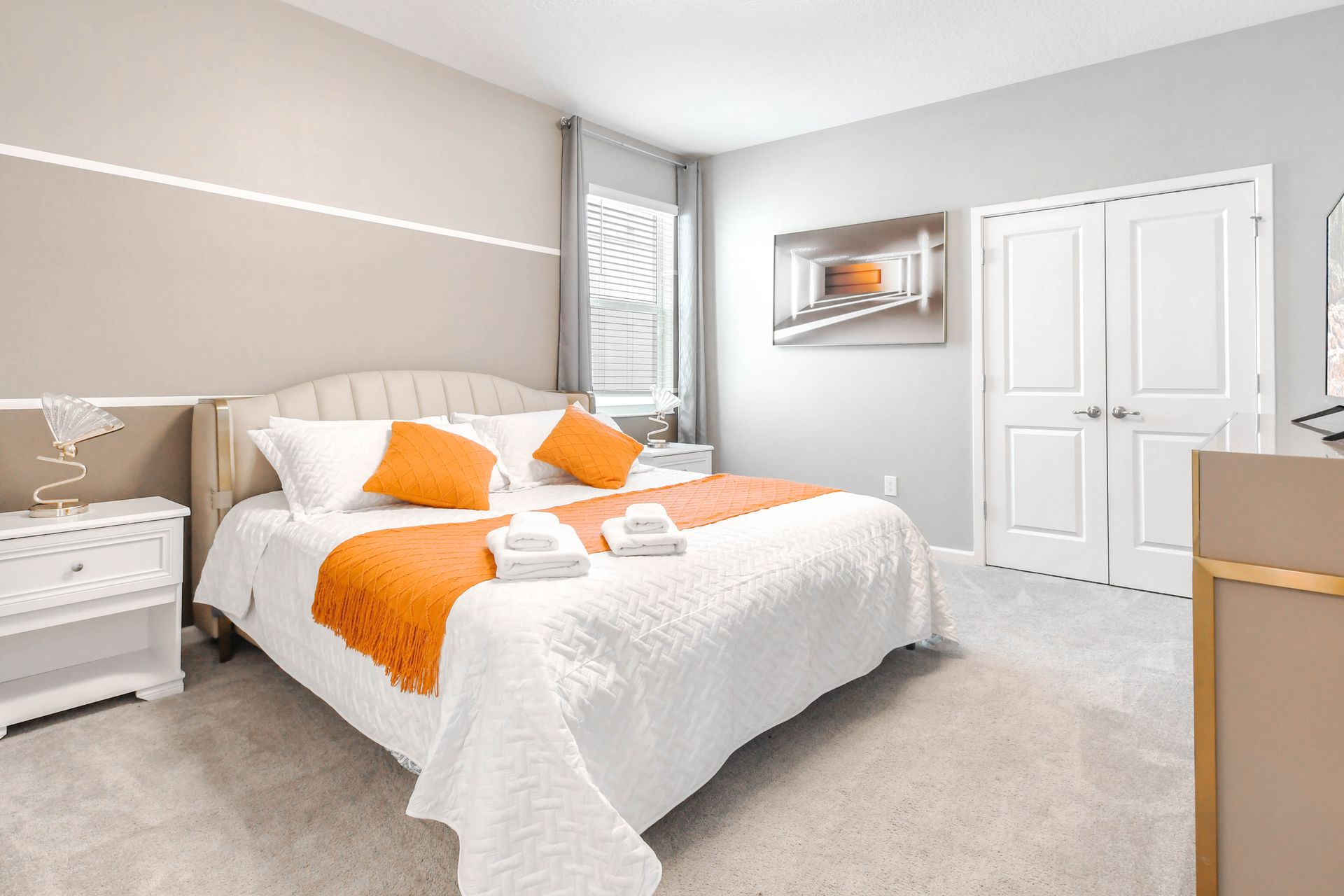 Contemporary king bedroom with bright accents, plush carpet, and modern artwork.