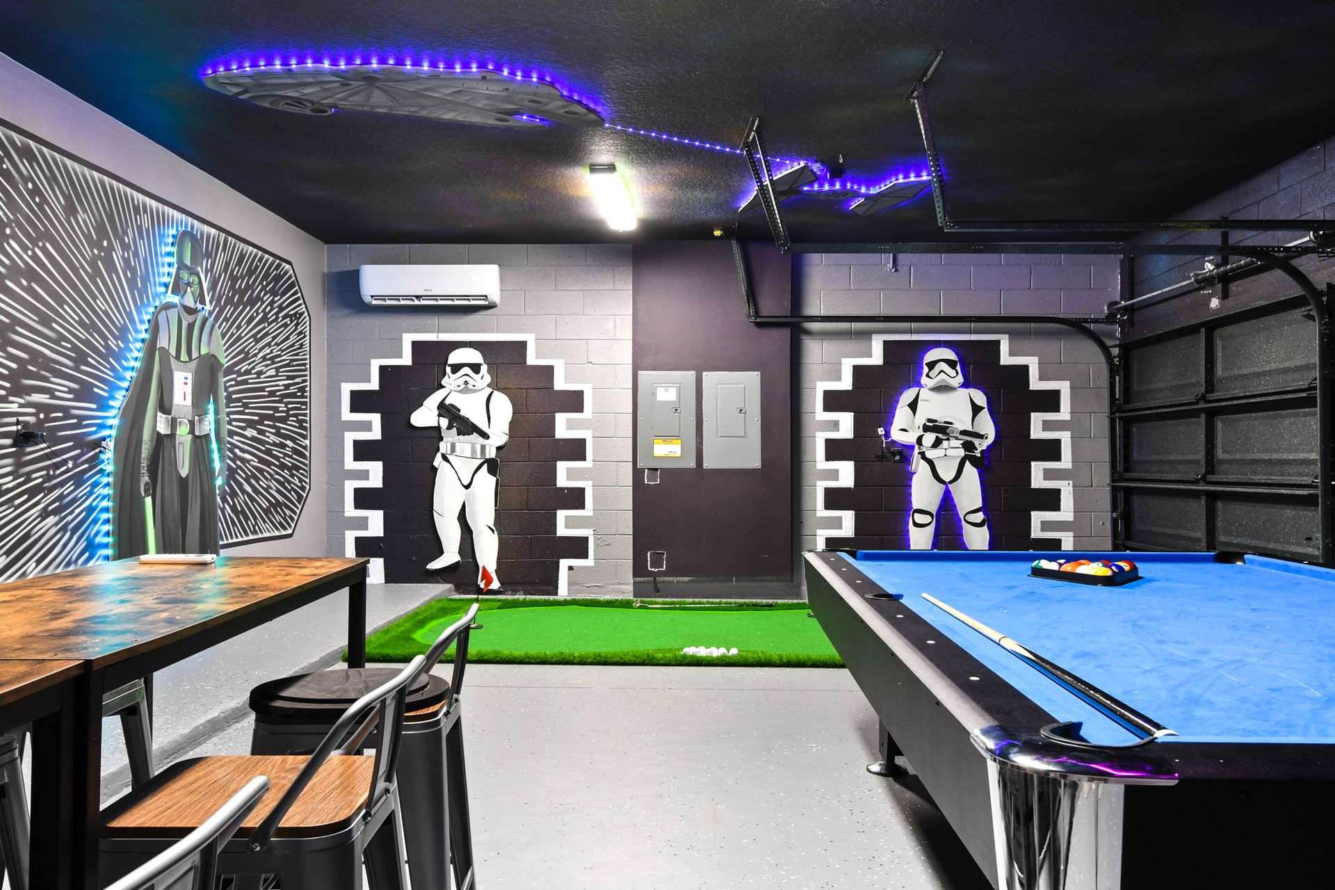 Star Wars-inspired game room with pool table, putting green, and neon accents.