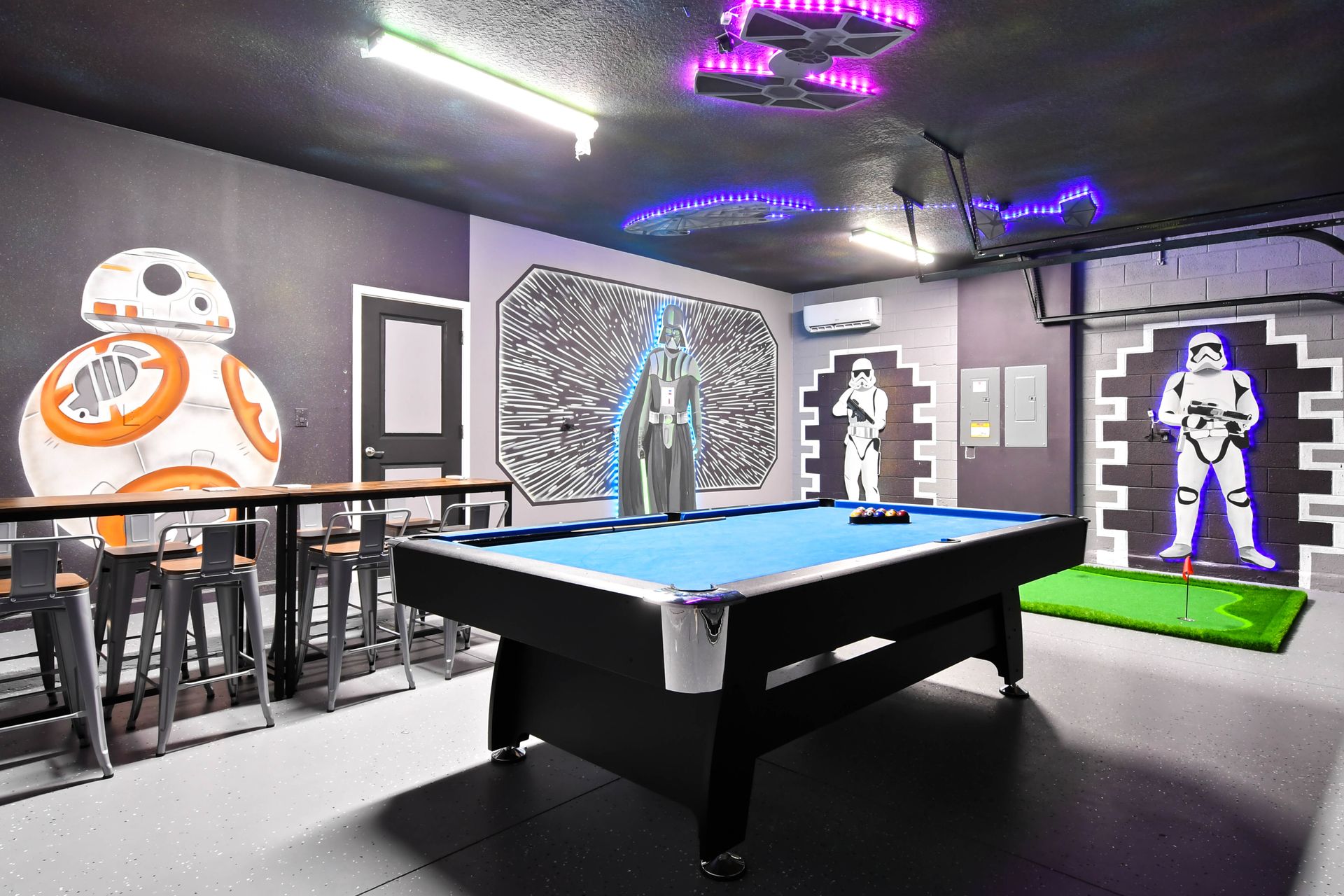 Galaxy-themed game room with pool table, bar seating, and immersive wall art.