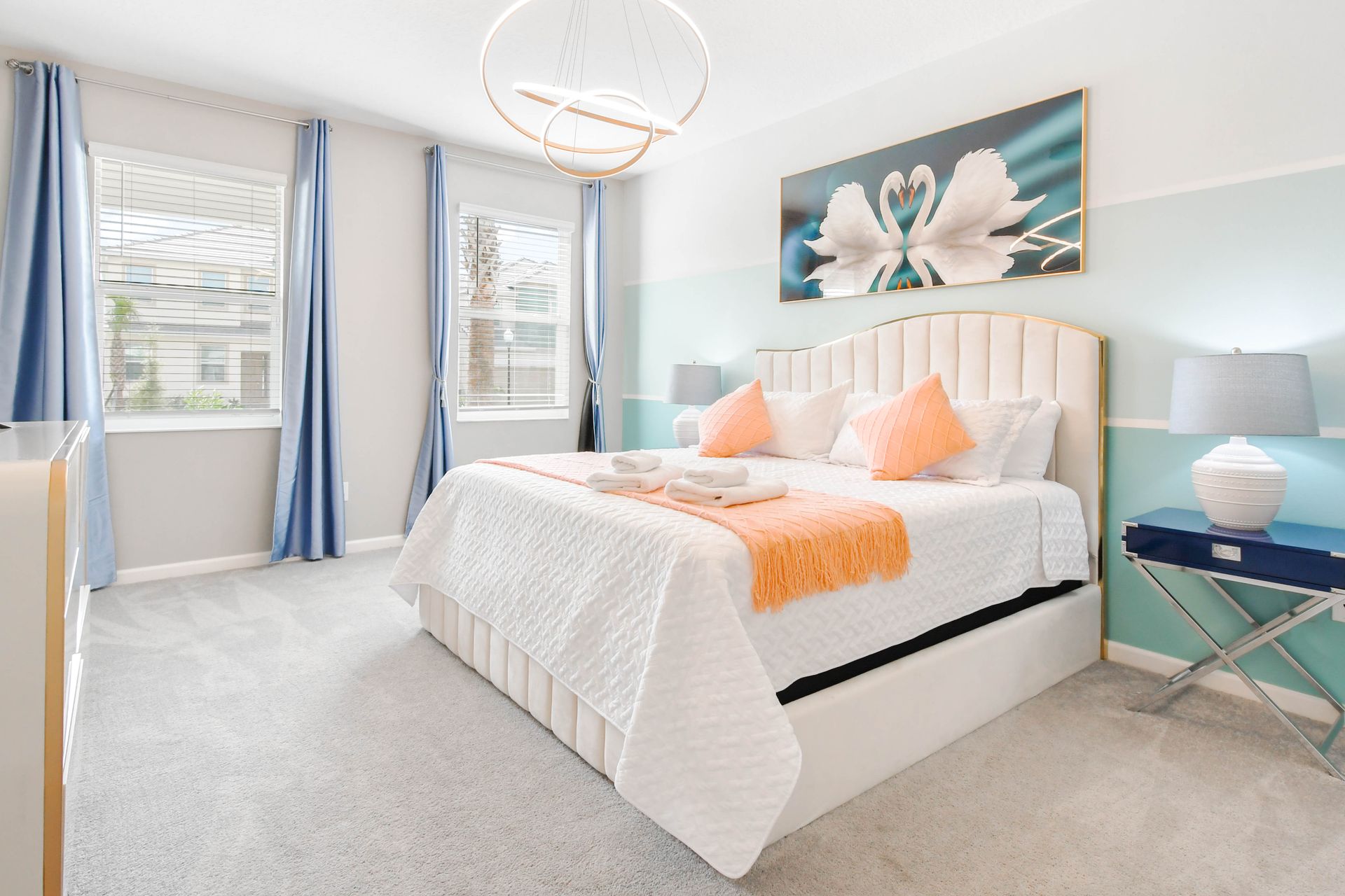 This bedroom is bright and airy, featuring soft blue and white walls with a horizontal stripe detail.