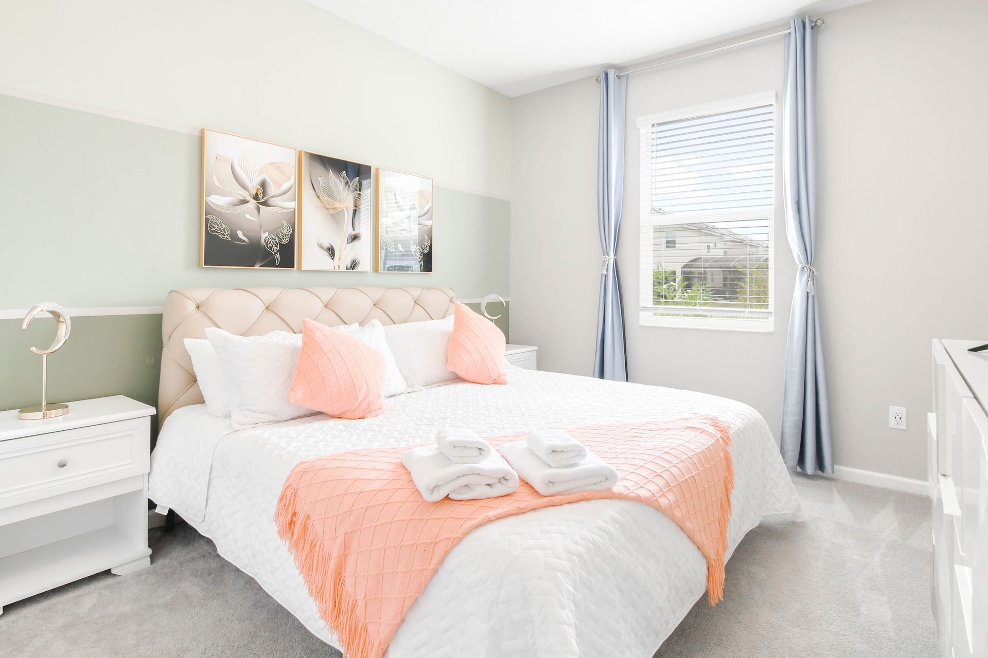 Charming king bedroom with soft pastel tones, stylish decor, and natural light.