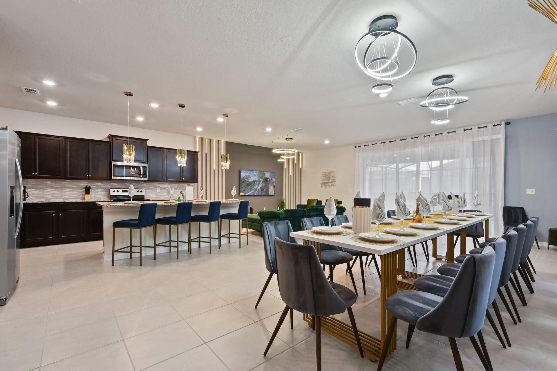 Modern open layout with gourmet kitchen, elegant dining, and designer lighting.
