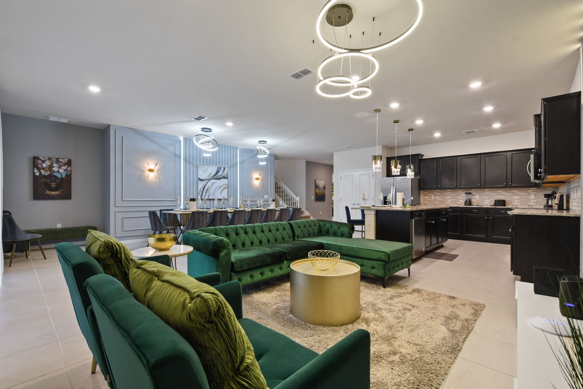 Elegant open-concept space with luxe velvet seating and a sleek modern kitchen.
