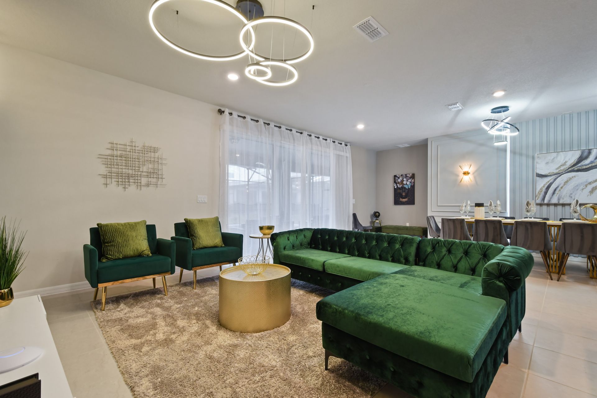 Spacious designer lounge with plush green seating, chic décor, and natural light.
