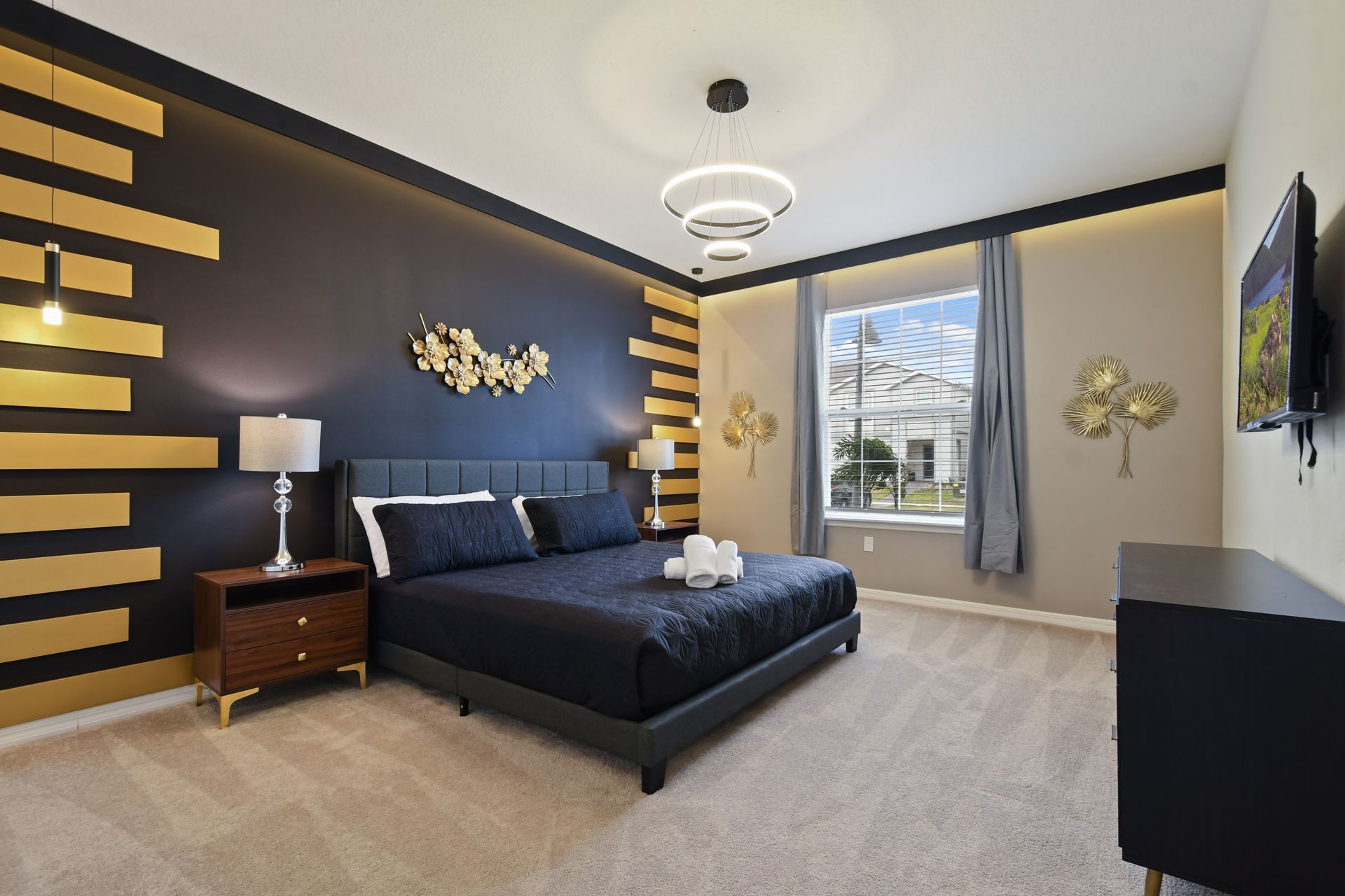 Sophisticated bedroom with bold accents, plush king bed, and modern lighting.
