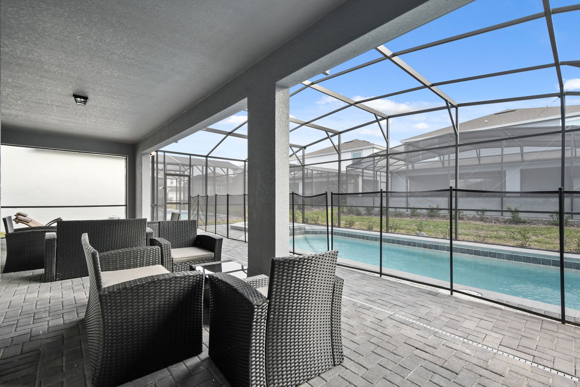 Relax in the shade with poolside seating in this screened outdoor lounge retreat.
