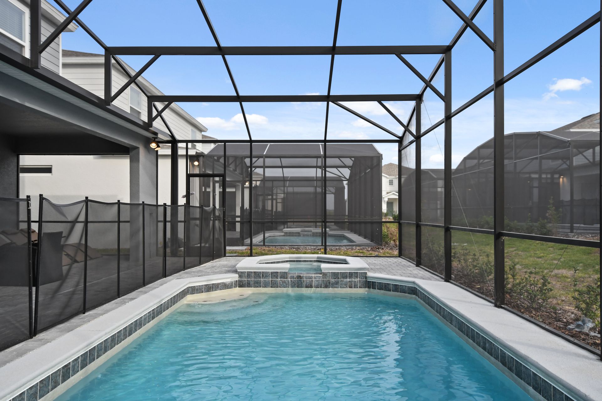 Private screened-in pool and spa with lounge seating and a spacious patio area.
