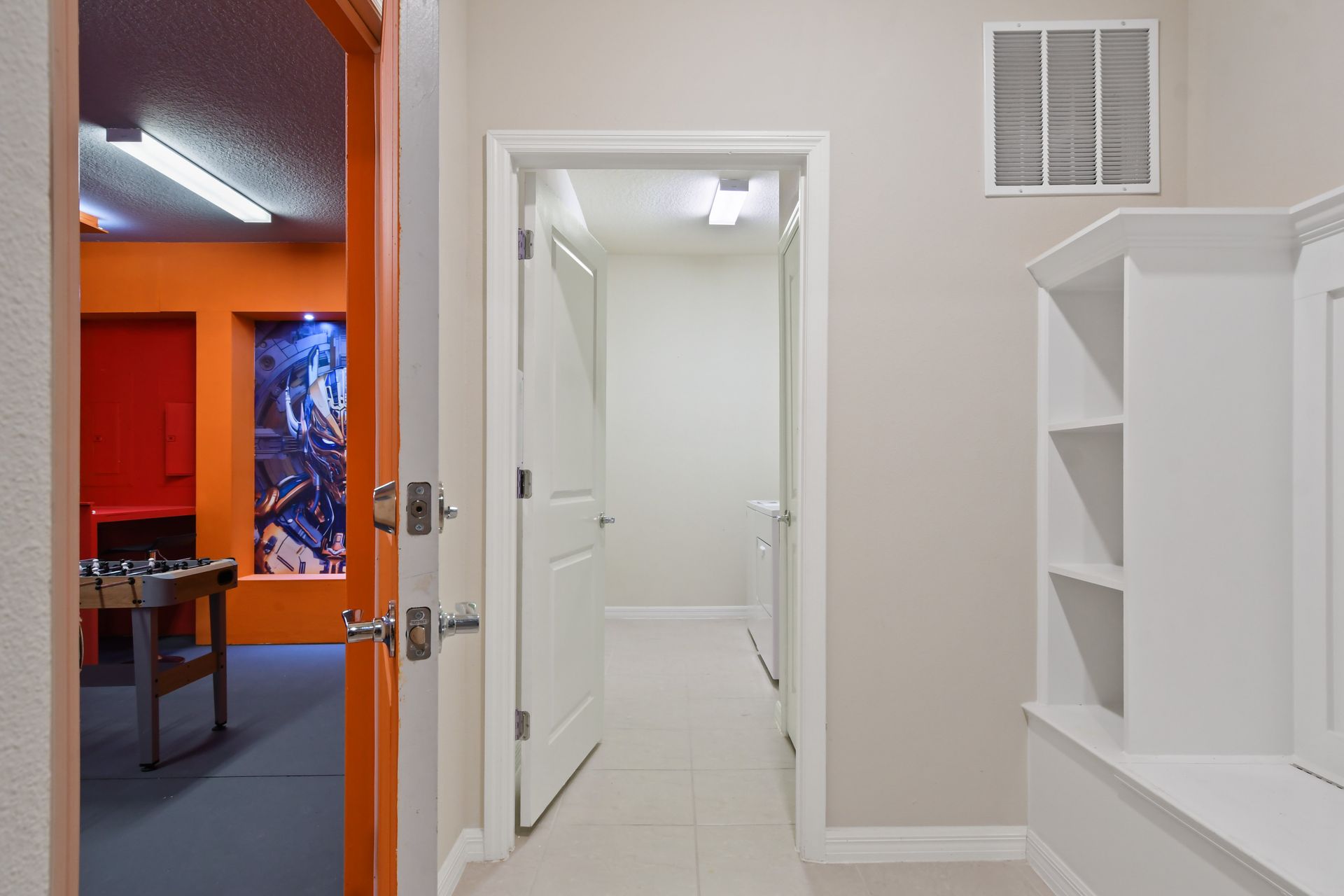 Bright hallway with laundry access and entry to vibrant game room full of fun.