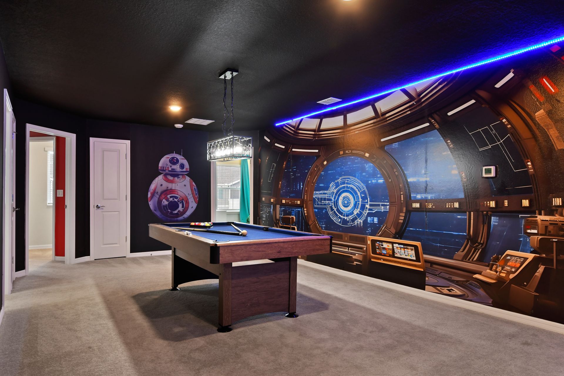 Galaxy-themed game loft with pool table, LED-lit theater, and space wall art.

