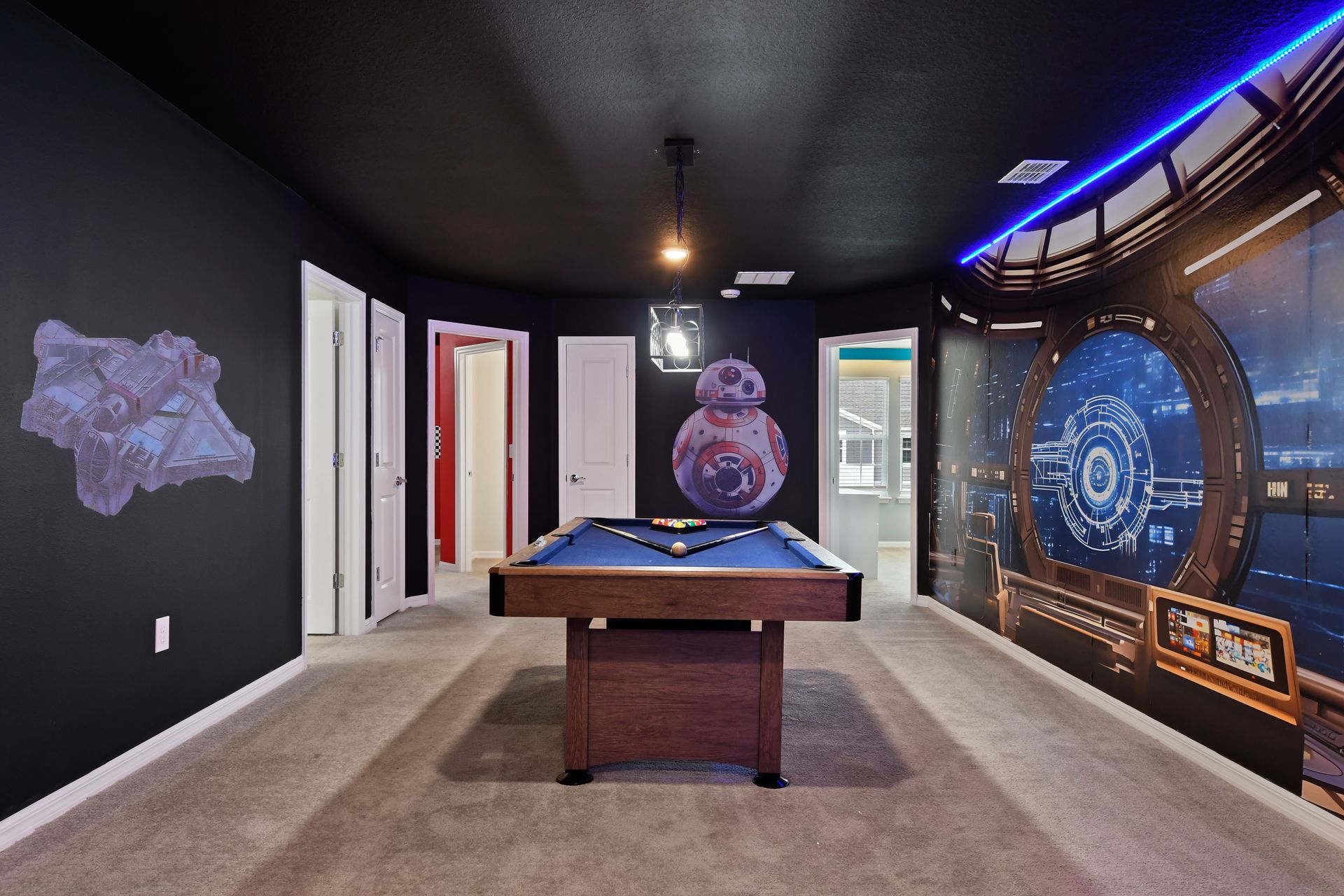 Galaxy-themed game loft with pool table, LED-lit theater, and space wall art.
