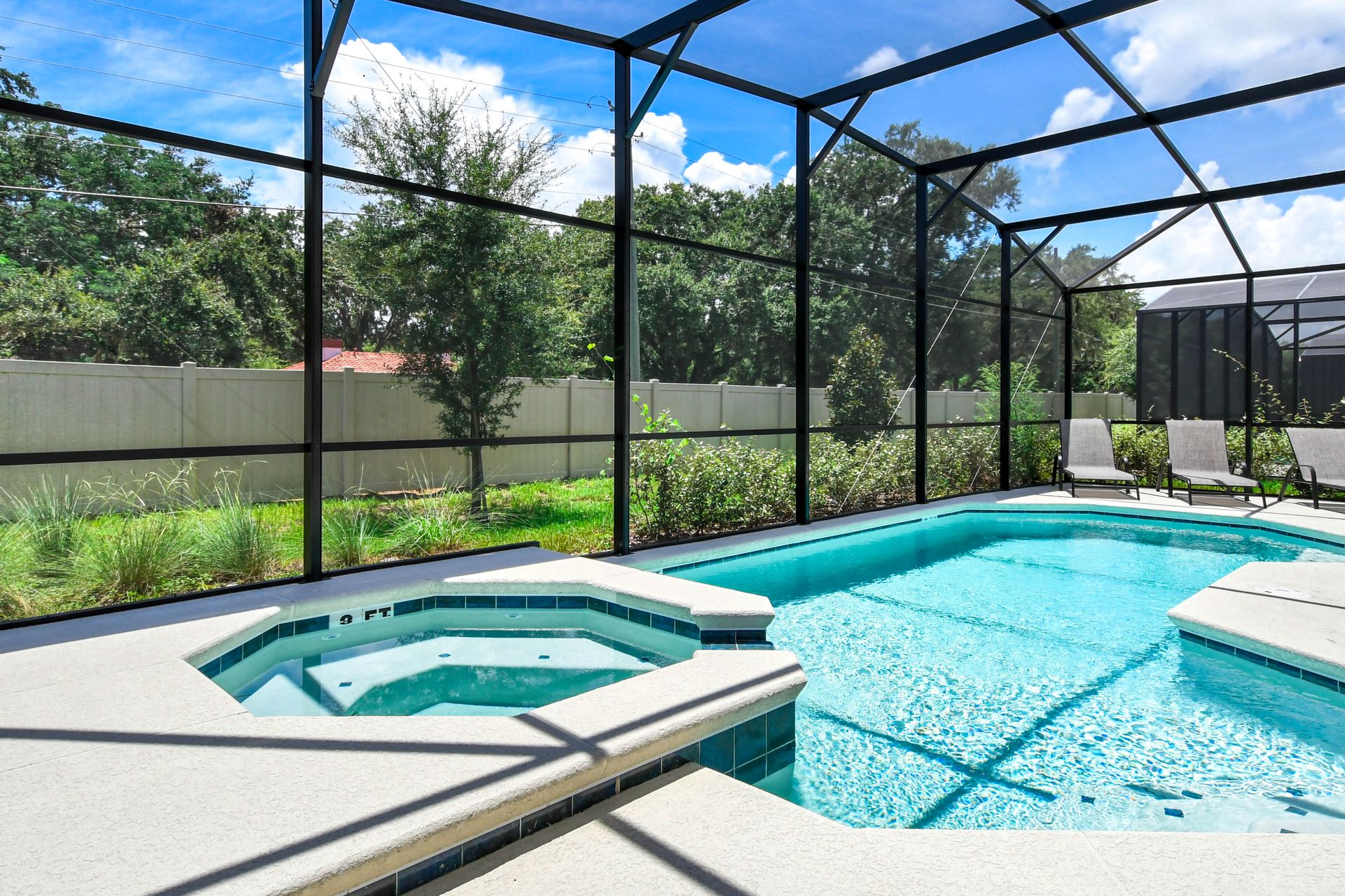 Relax in a private screened-in pool and spa with lush views and comfortable loungers.