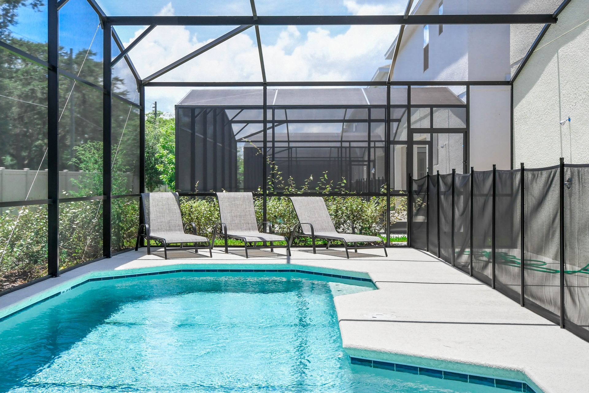 Enjoy a private screened-in pool with lounge chairs, perfect for soaking up the sun.