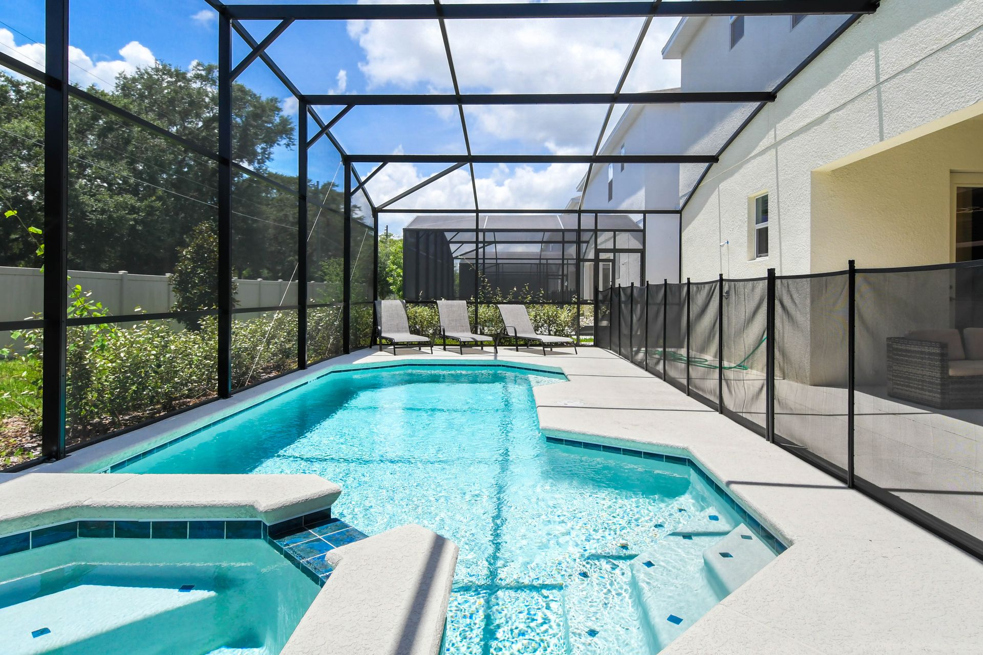 Private screened-in pool and spa with lounge chairs, sunny views, and total relaxation.