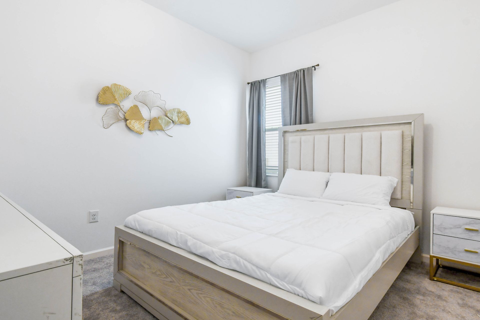 Elegant bedroom with a plush bed, gold accents, and a sleek, modern design.