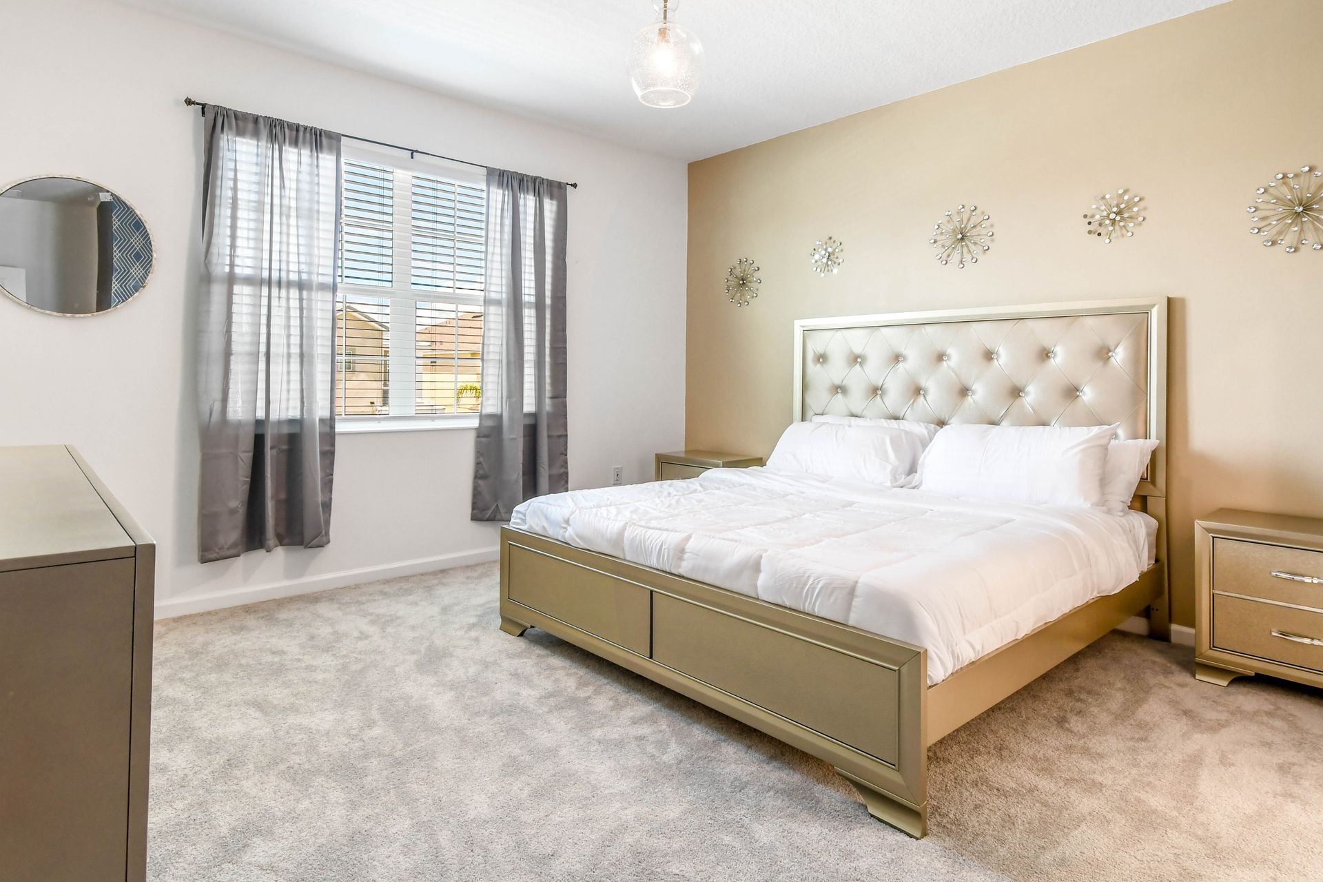 Elegant bedroom with a plush king bed, gold accents, and a stylish, relaxing vibe.
