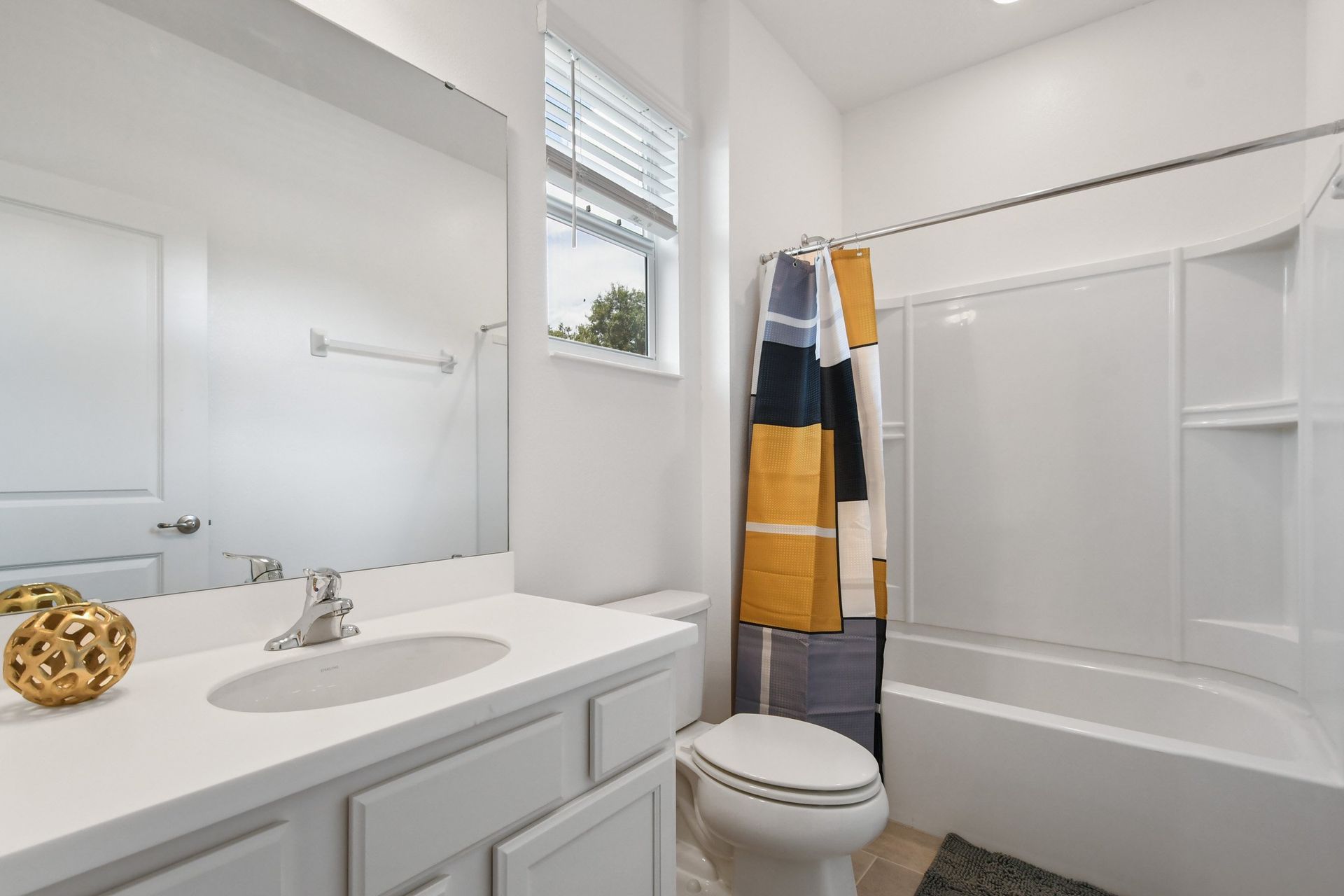 Bright and modern bathroom with a sleek vanity, large mirror, and stylish shower curtain.