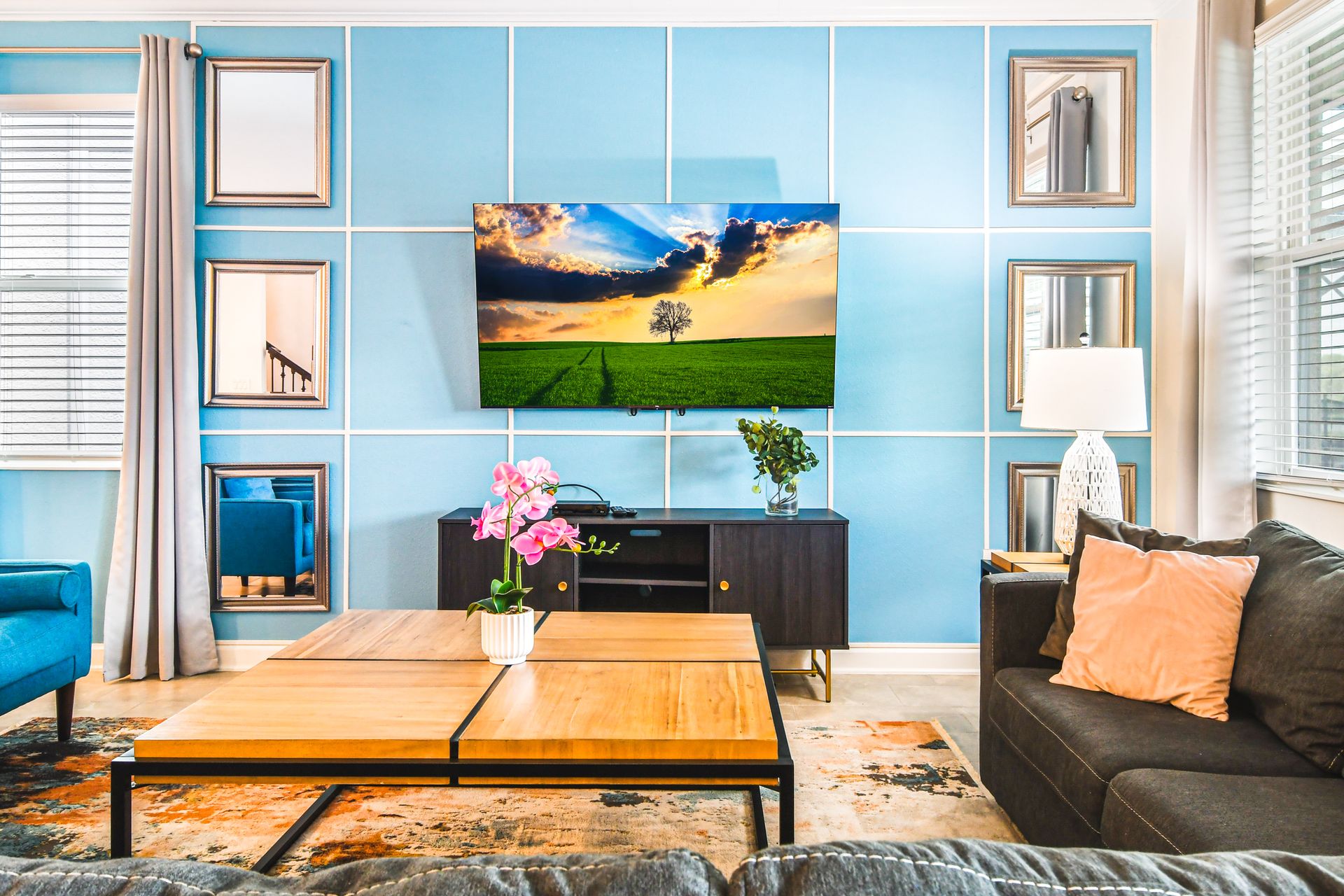 Bright and modern living room with stylish decor, comfy seating, and a smart TV.