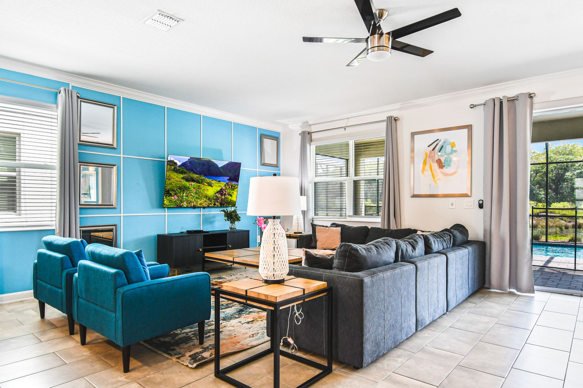 Relax in style! Spacious living area with pool views, modern decor, and cozy vibes.