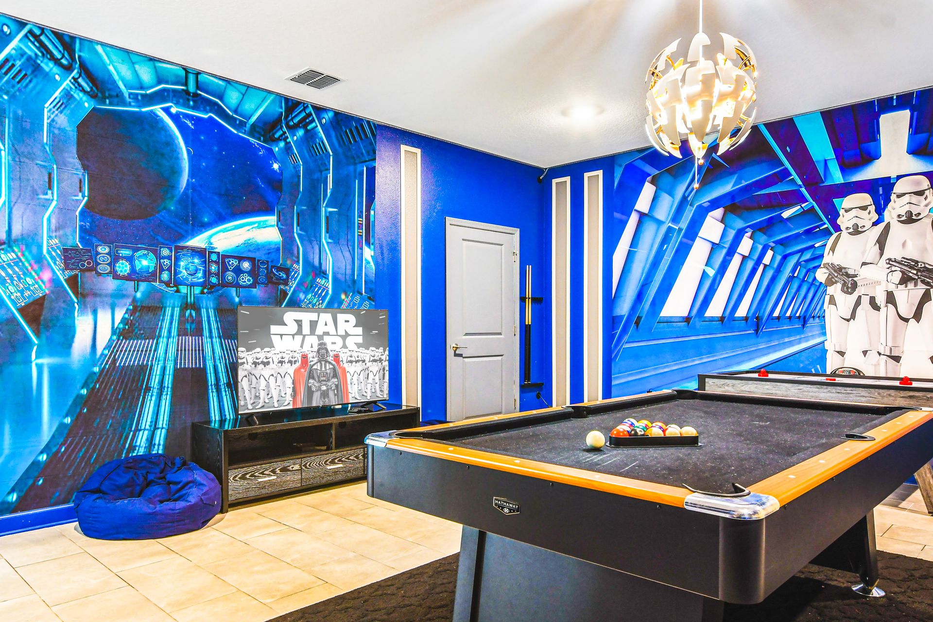 Step into a galaxy far, far away! Game room with pool table & epic space-themed decor.