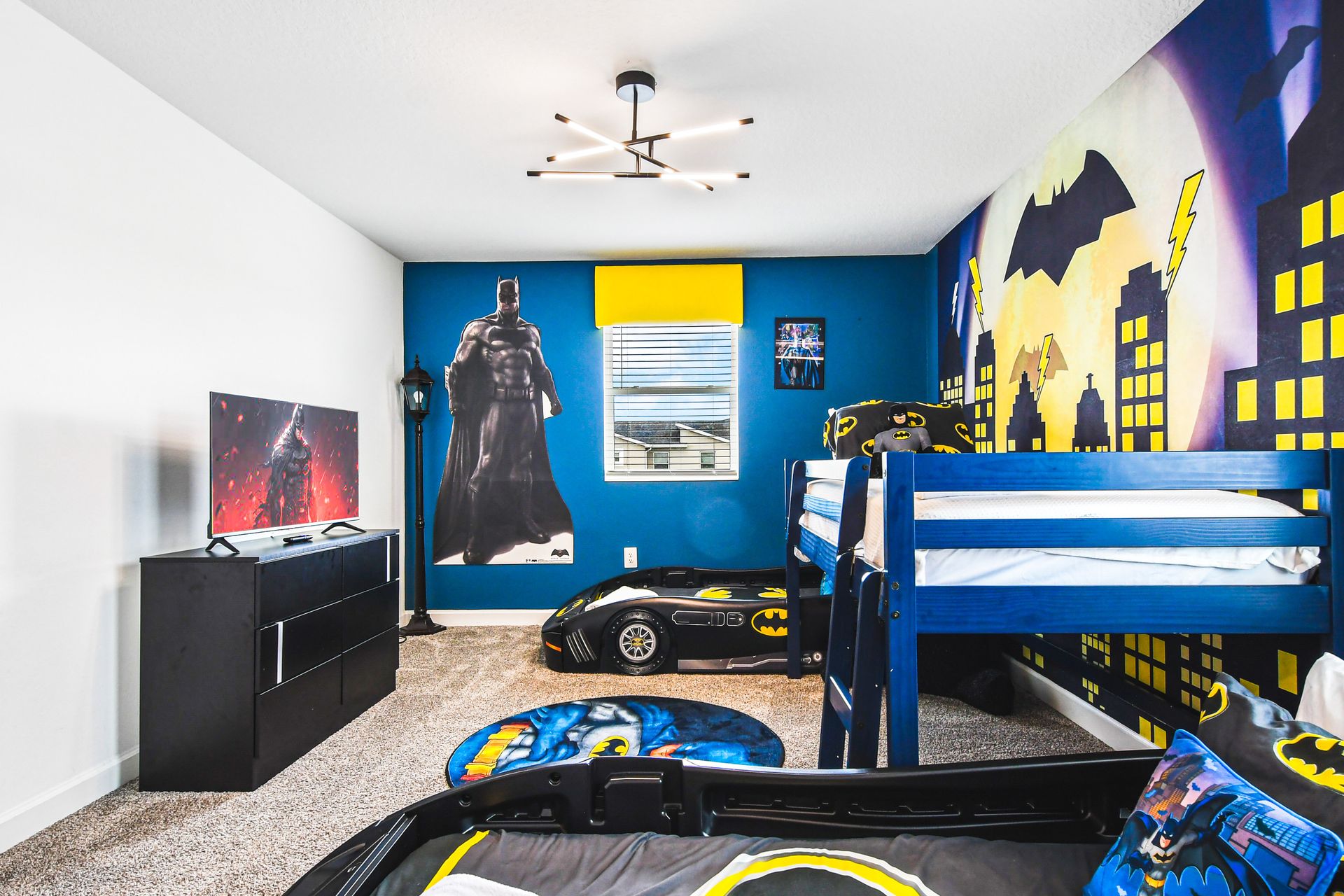 Dynamic Batman-themed room with cityscape mural, Batmobile bed, and superhero decor.