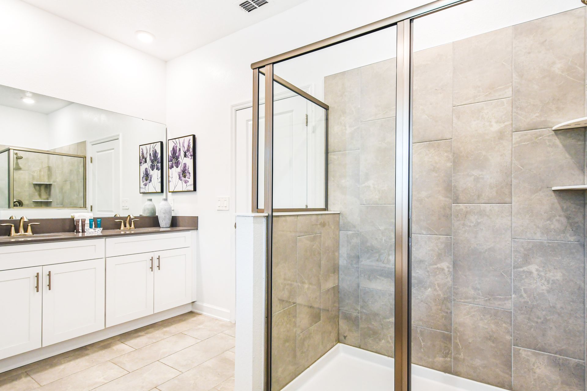 Elegant bathroom featuring a spacious glass shower, dual vanity, and modern decor.