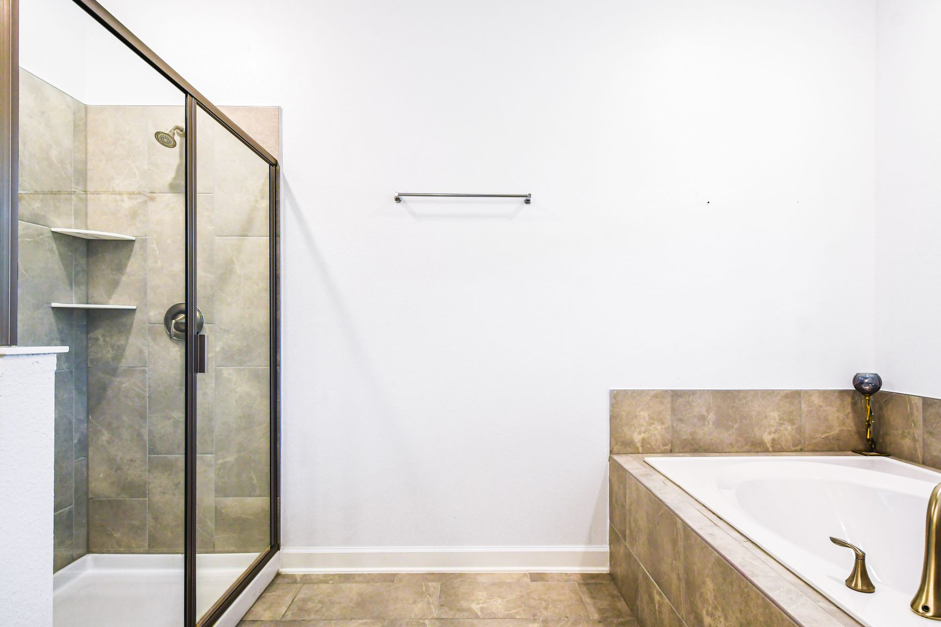 Spacious bathroom with a glass-enclosed shower and a luxurious soaking tub.