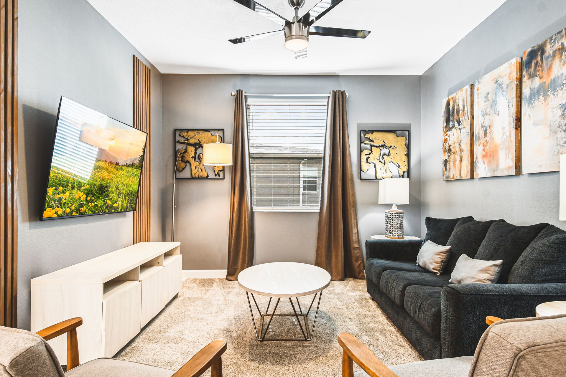 Cozy media room with plush seating, smart TV, and modern artistic accents