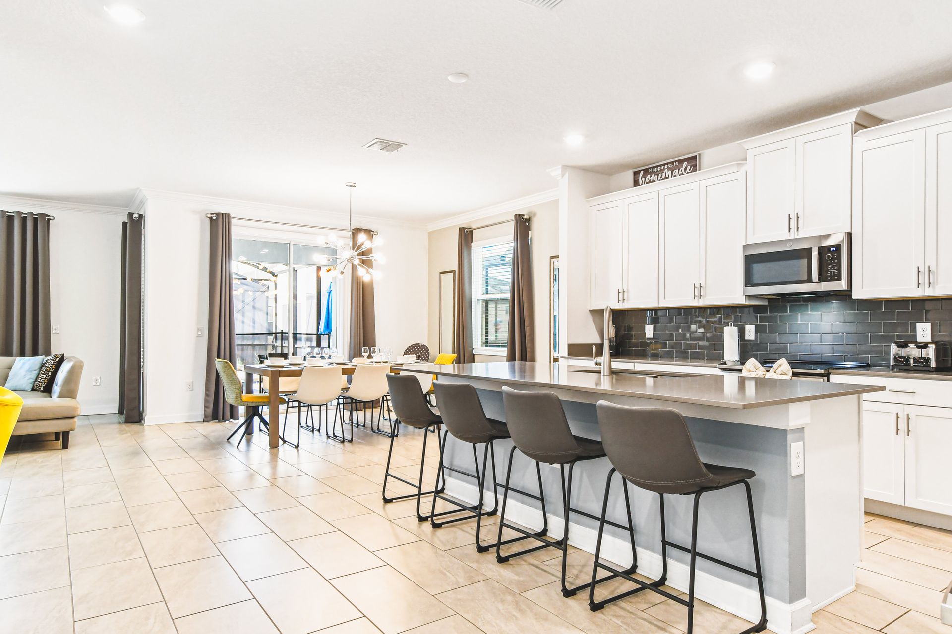 Spacious chef’s kitchen with large island, sleek finishes, and seating for six
