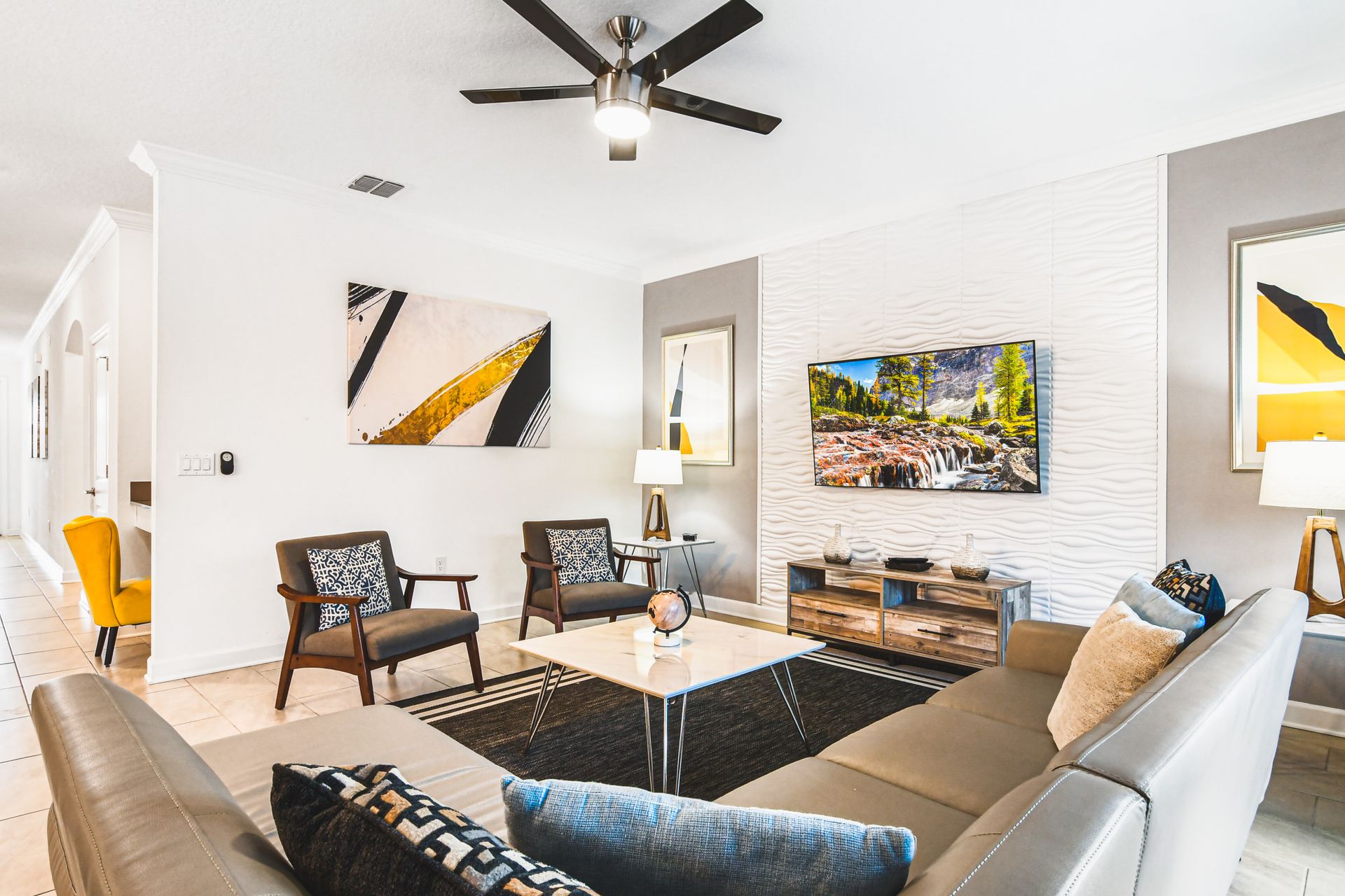 Bright and stylish living area with smart TV, modern art, and comfy seating