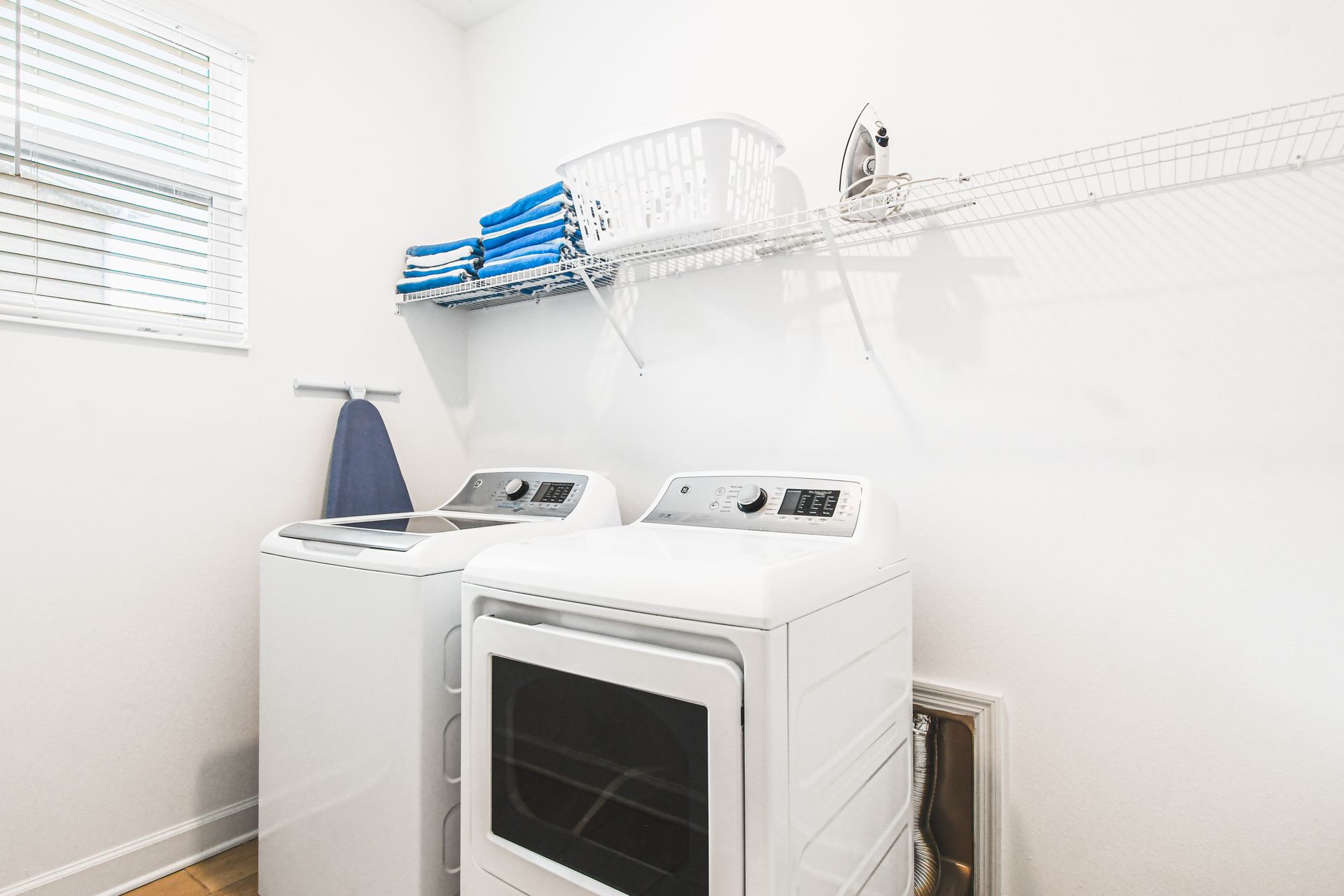 Laundry room with washer, dryer, ironing board, and plenty of shelf storage space