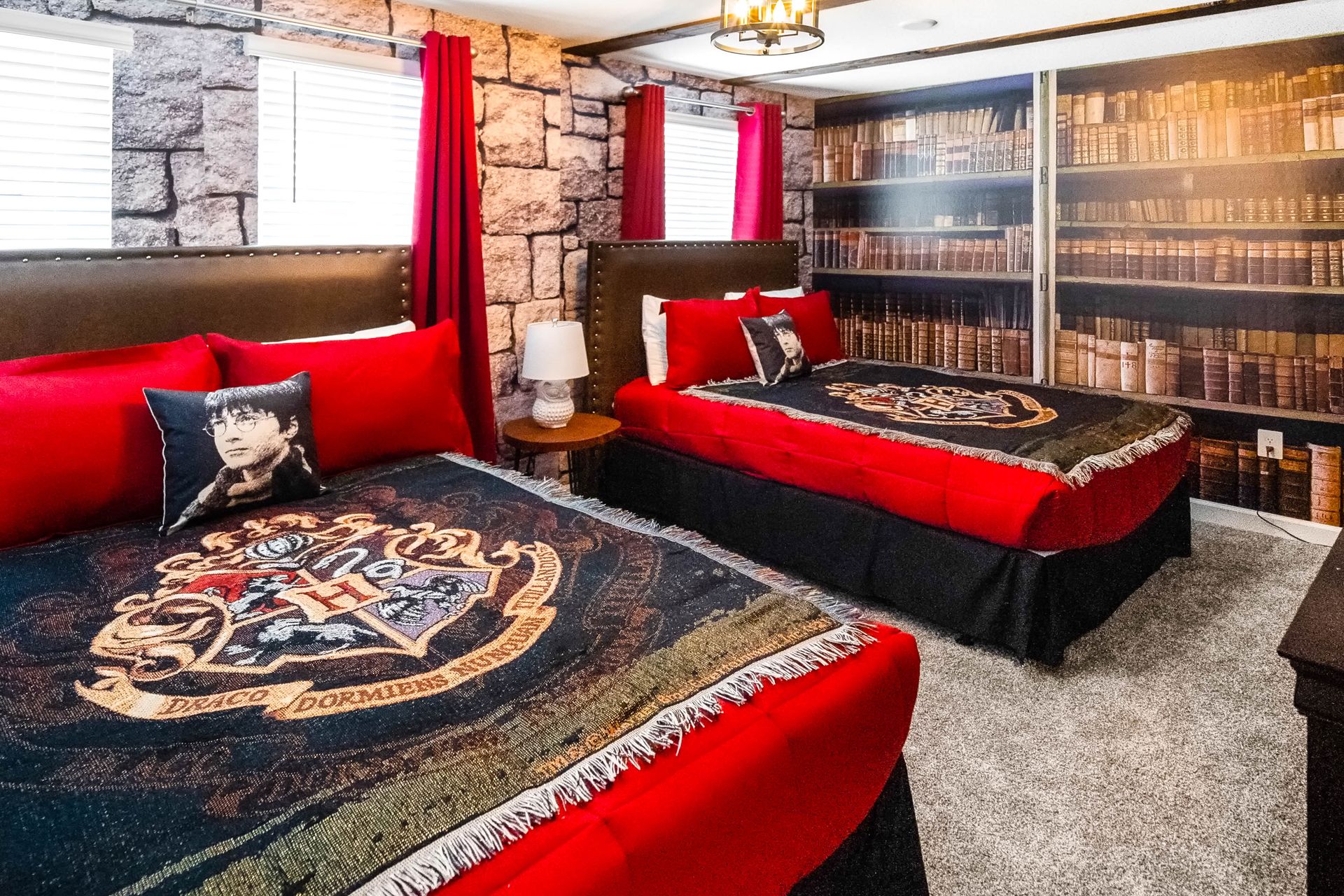 Enchanting Harry Potter-themed bedroom with Gryffindor decor, stone walls, and library mural.